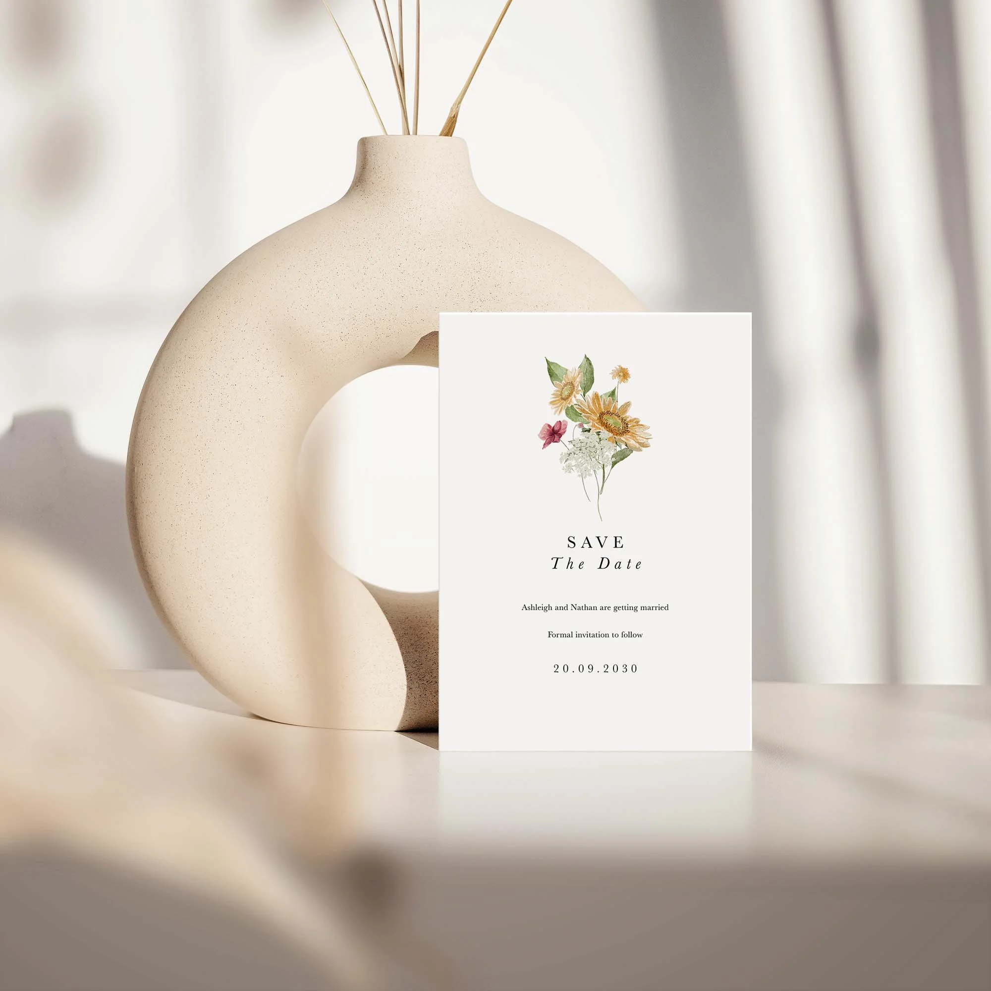 Autumn Sunflower save the date card with sunflower and wildflower design displayed against a cream ceramic vase on a neutral background