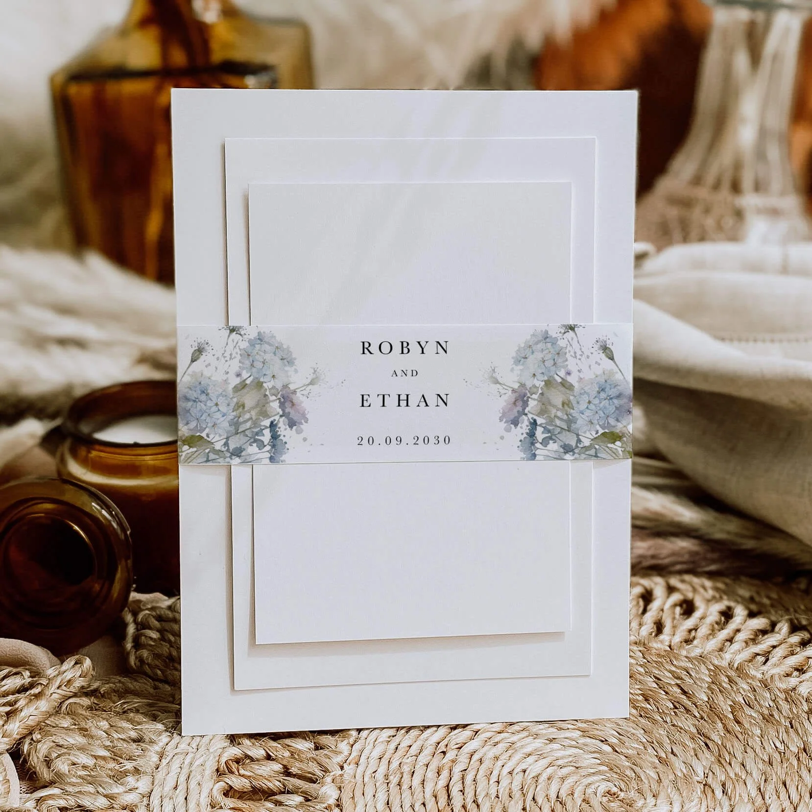 Dusty Blue personalised wedding belly bands with soft blue hydrangea watercolour illustration wrapped around wedding invitations