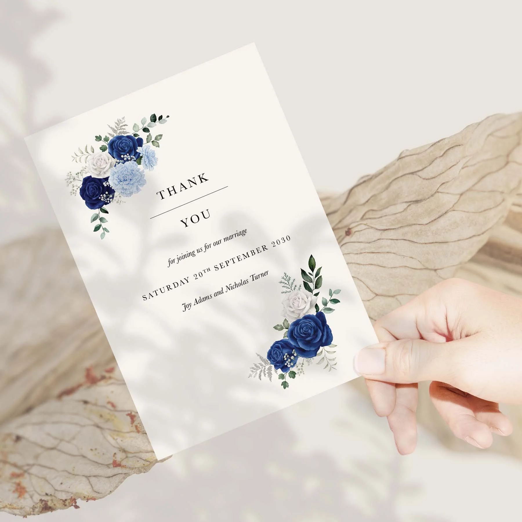 Hand holding a Royal Blue and White Rose wedding thank you card