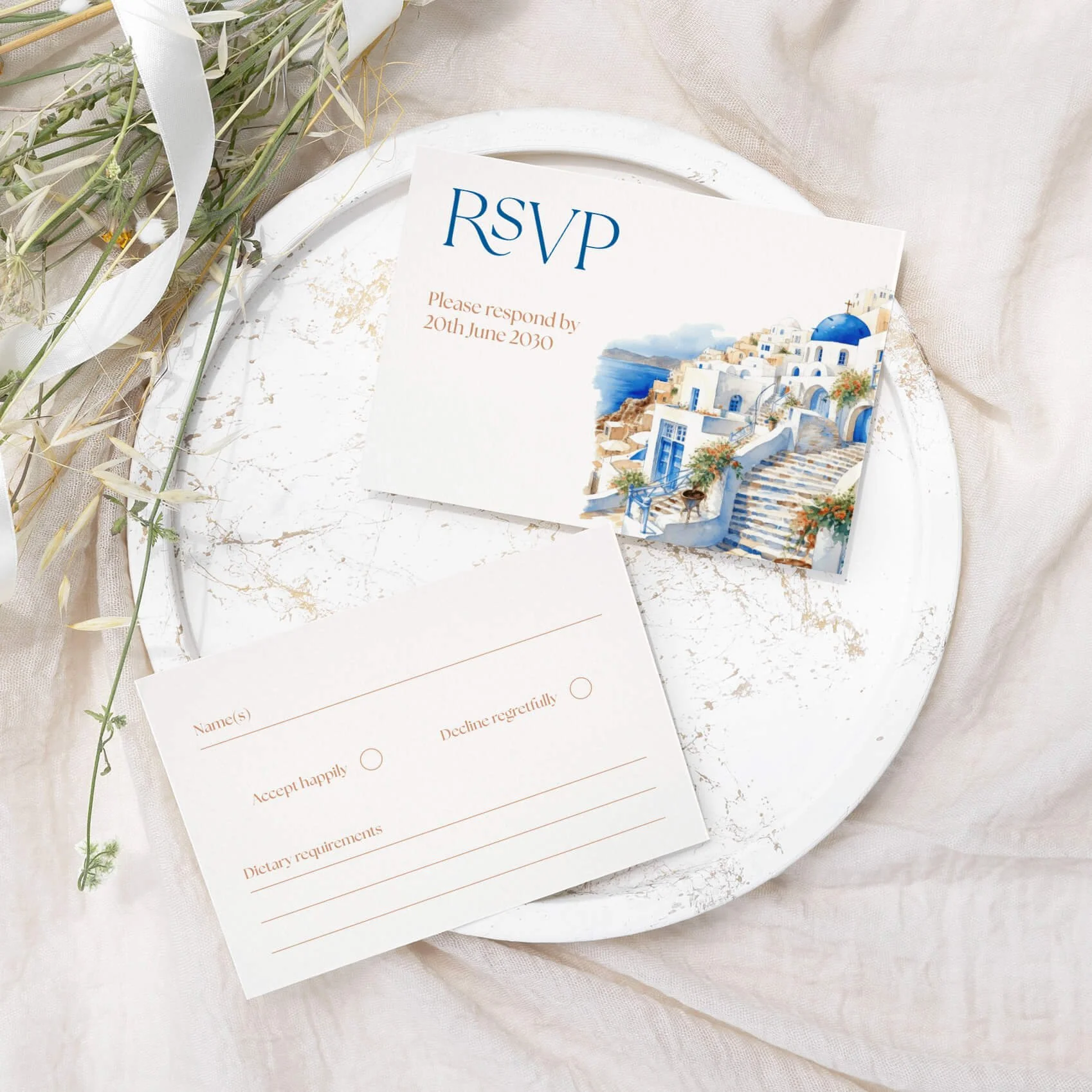 Santorini wedding RSVP card with watercolour Greek island village illustration and blue script typography on luxury off-white card