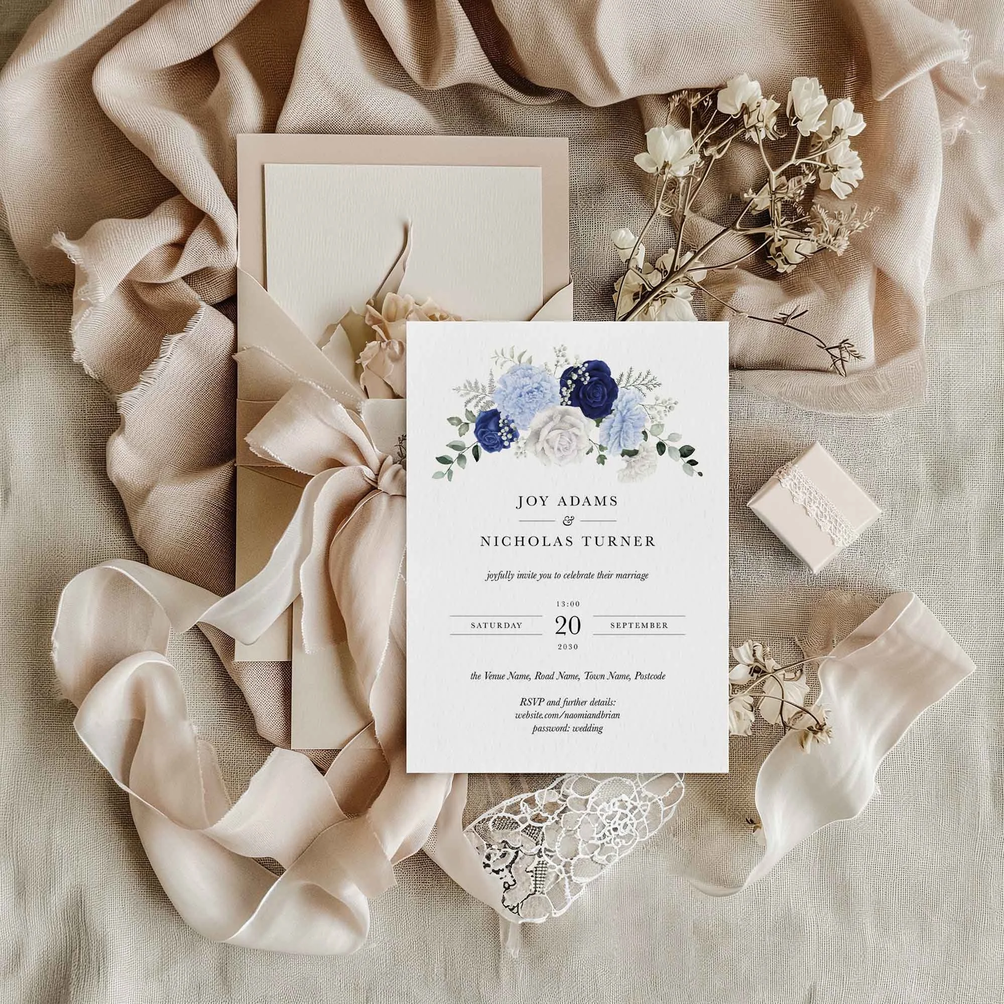 Blue and White Rose wedding invitation styled in a flat lay environment with wedding props