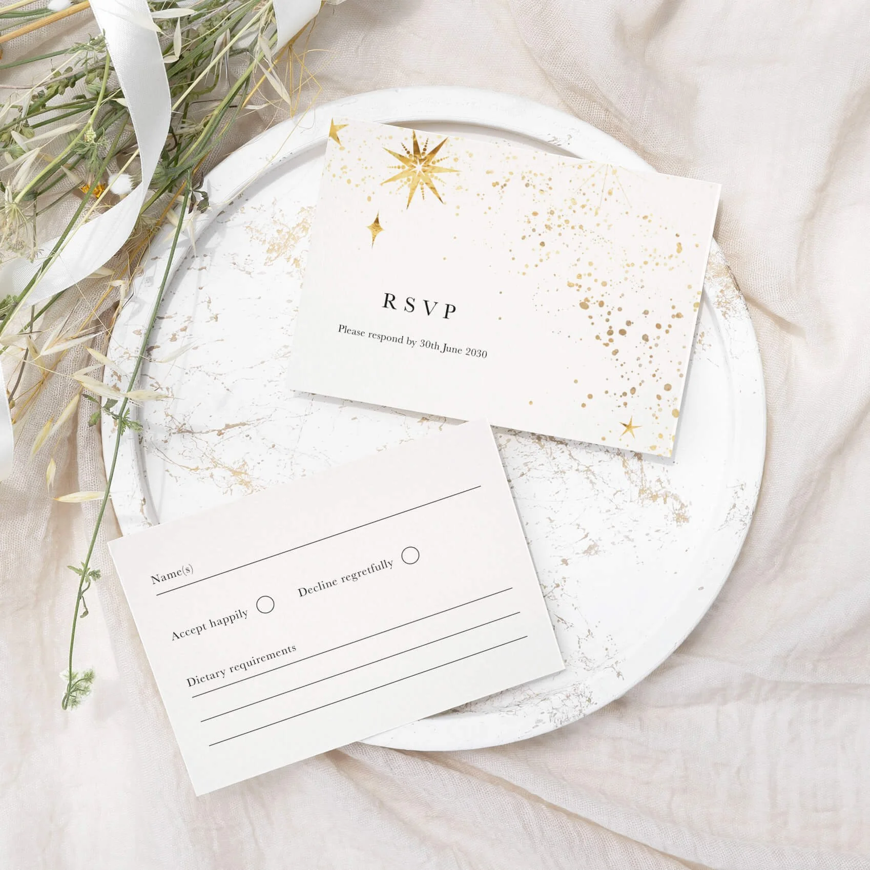Celestial wedding RSVP card with delicate gold star detailing and elegant luxury typography on off-white card