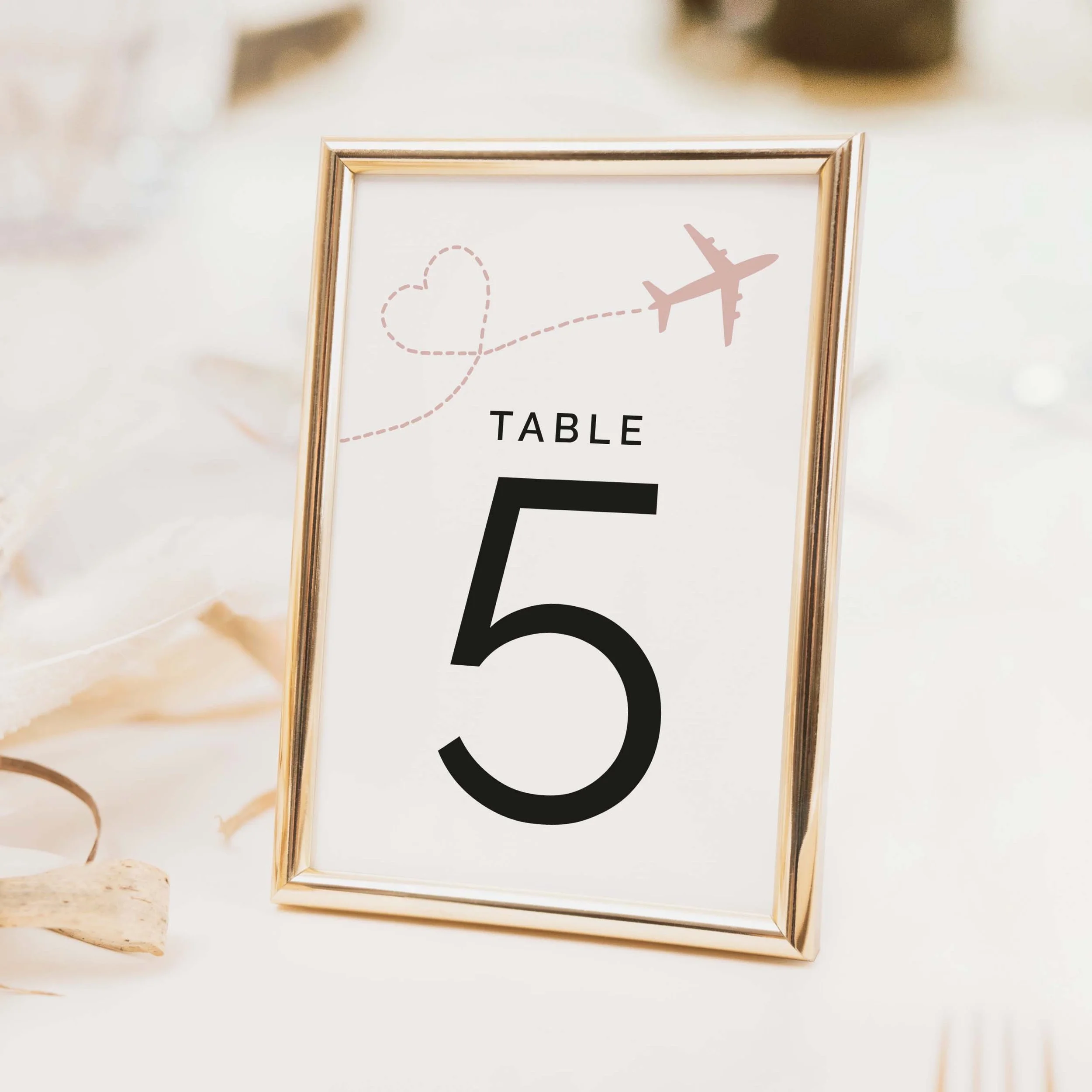 Travel themed wedding table number with aeroplane icon above bold numeral for destination and travel themed weddings on luxury off-white card