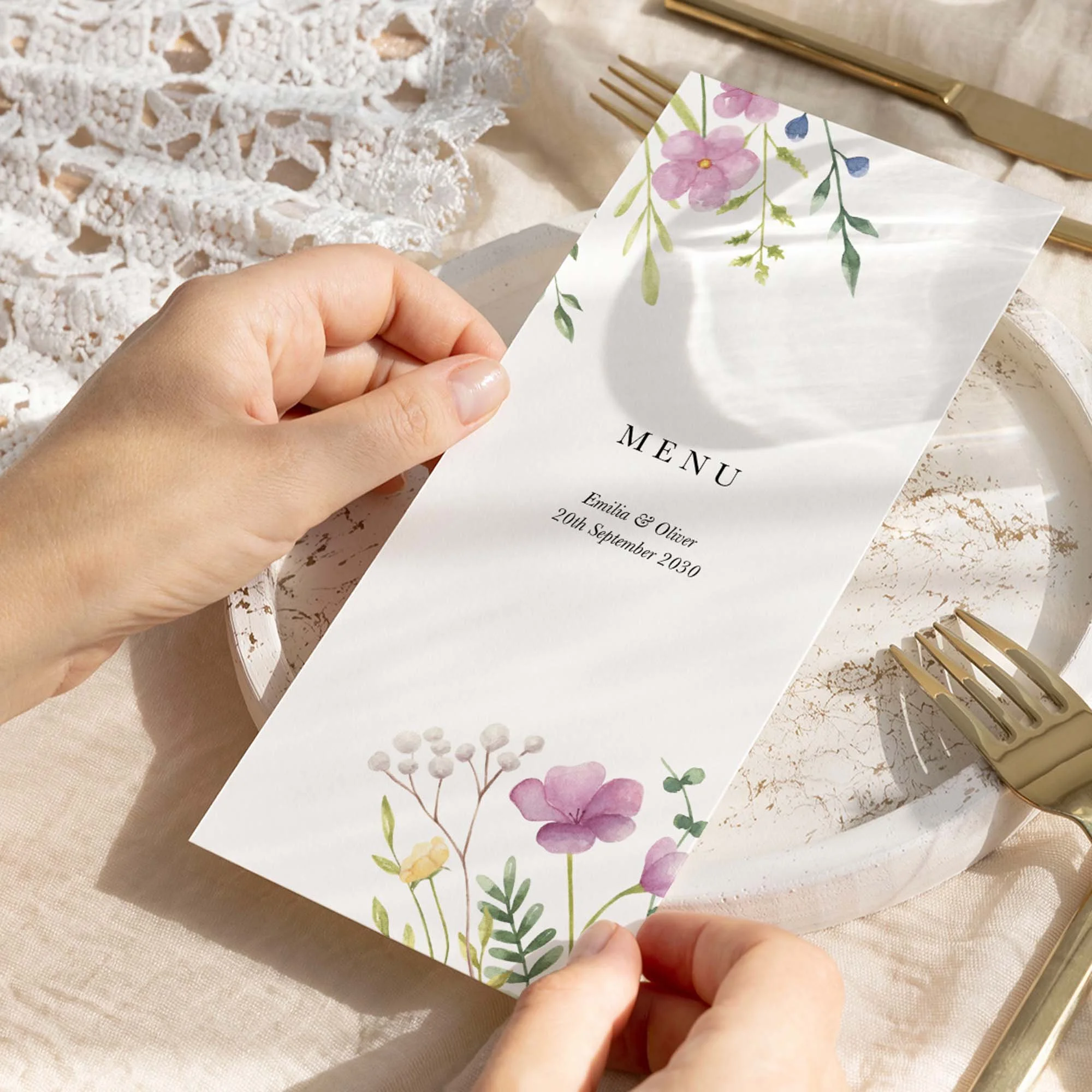 Hand holding Colourful Wildflower wedding menu card showing size and printed design details