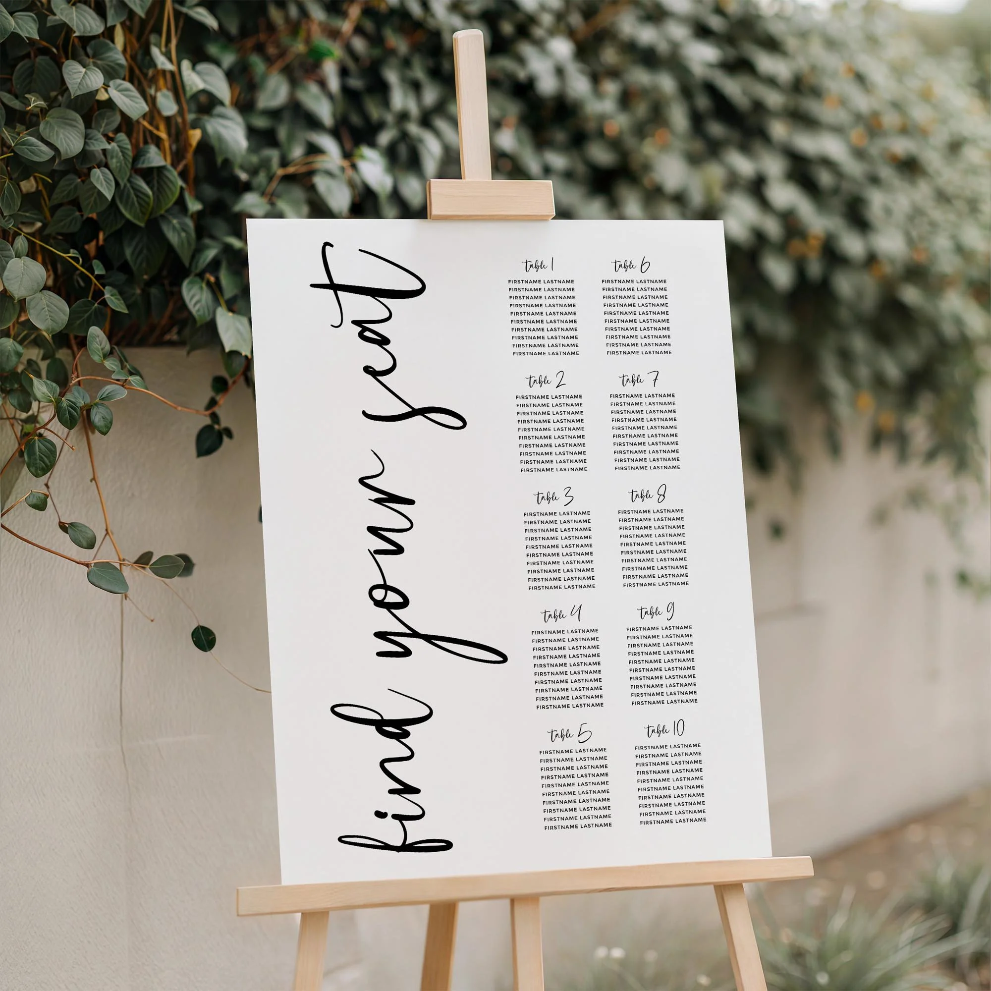 Close-up of the Black and White Calligraphy wedding seating plan board featuring large vertical handwritten lettering displayed outdoors