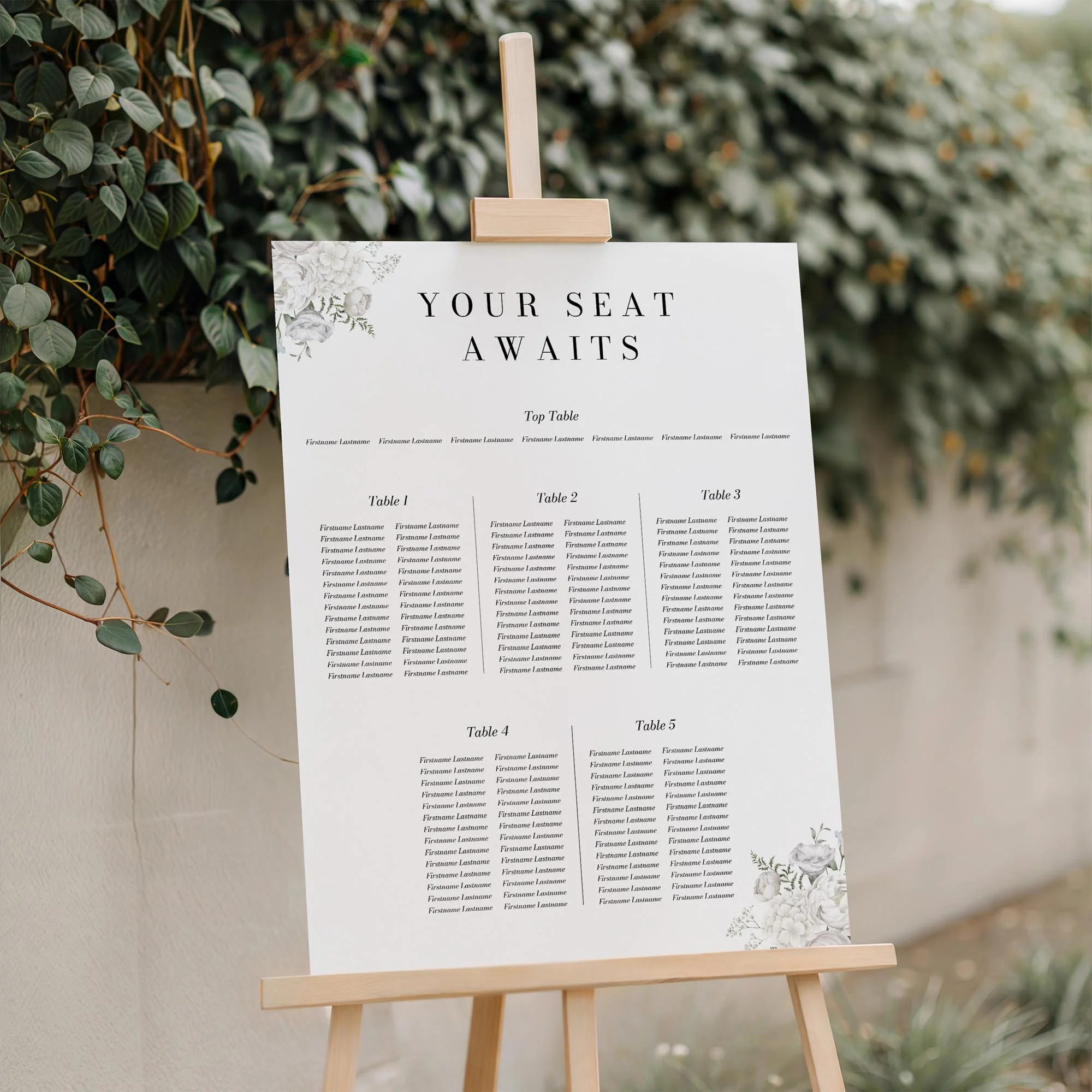 Close-up of the White Floral wedding seating plan board displayed outdoors