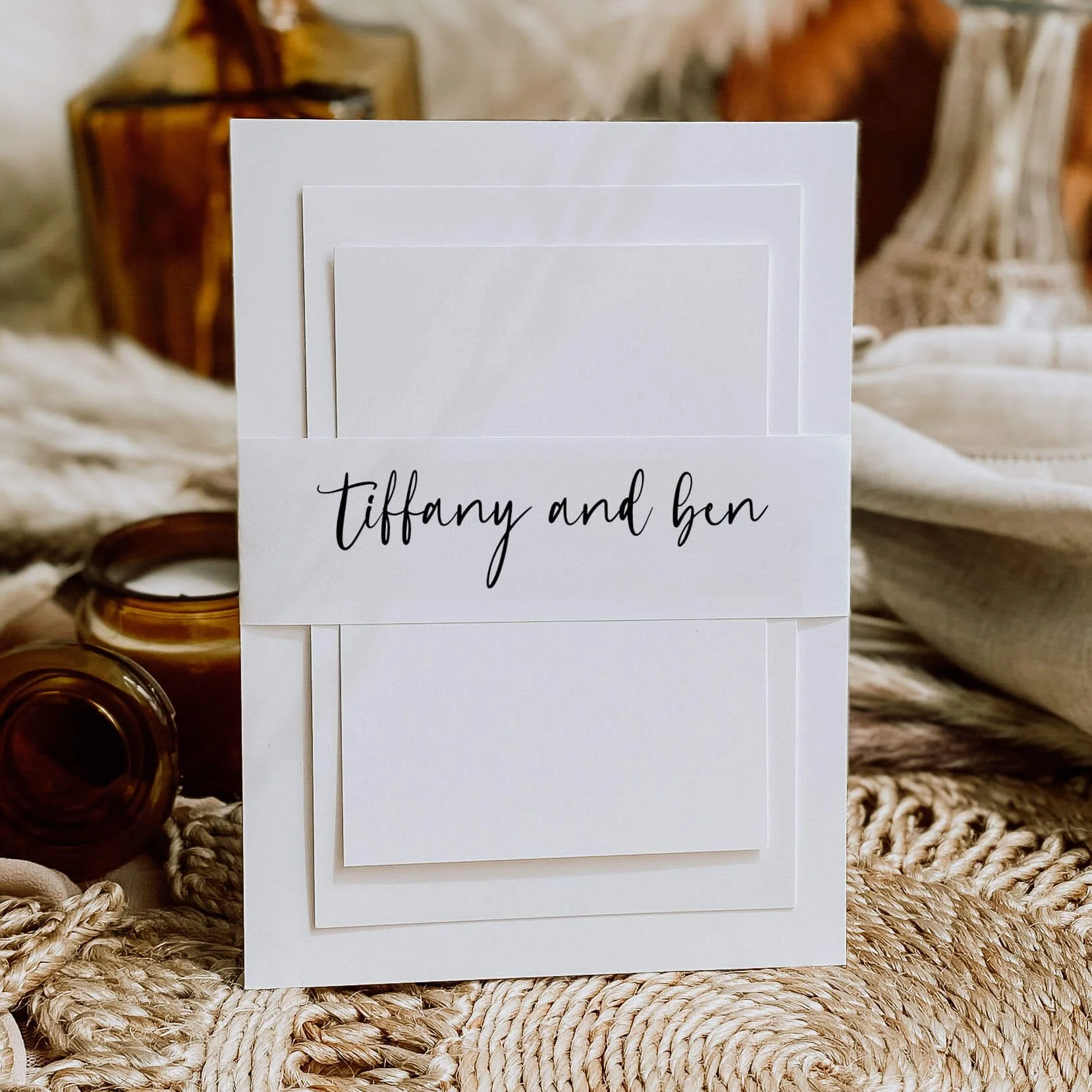 Script wedding belly band with elegant black handwritten calligraphy names wrapped around luxury wedding invitation suite