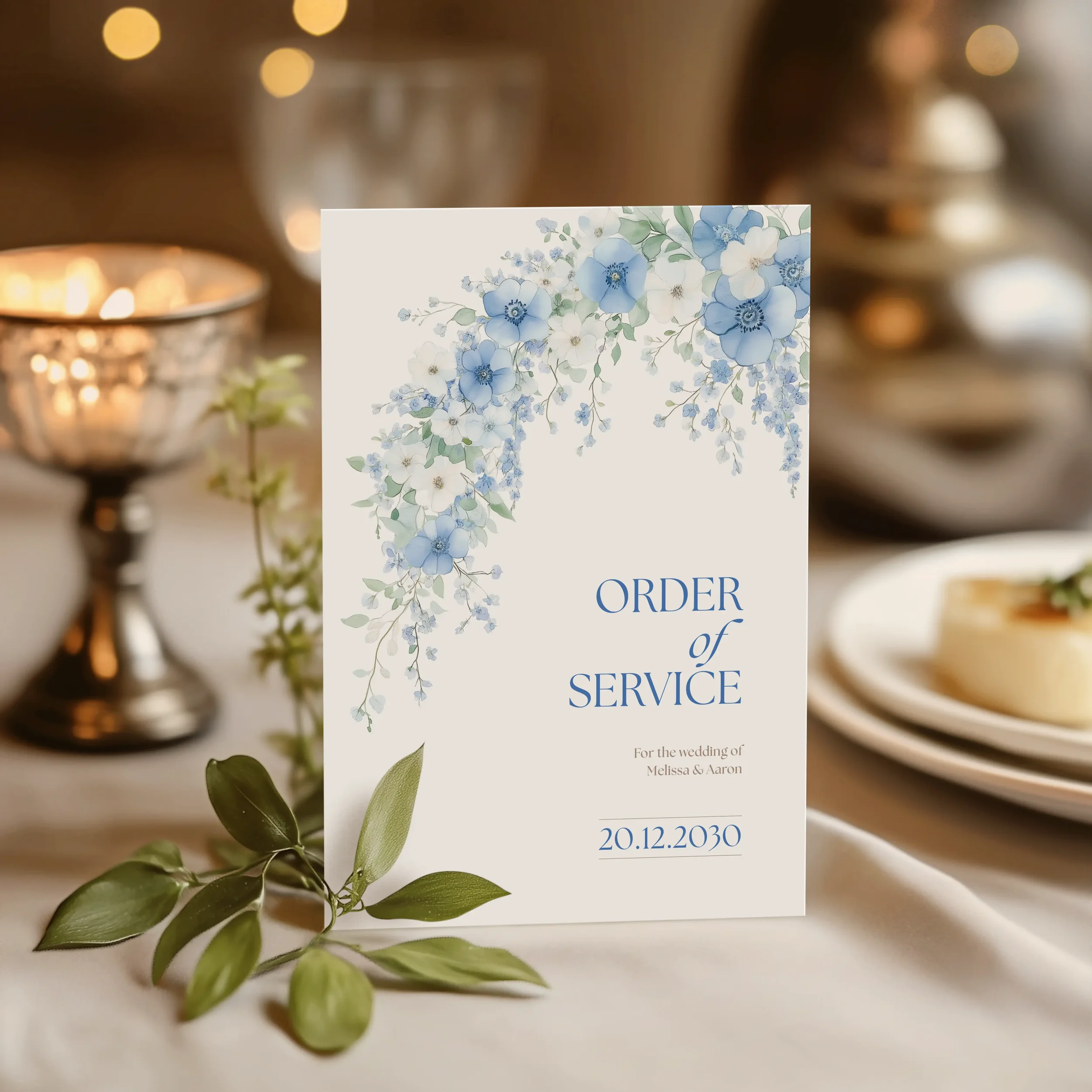 Serenity Order of Service booklet cover propped up at a wedding venue with blue floral design.