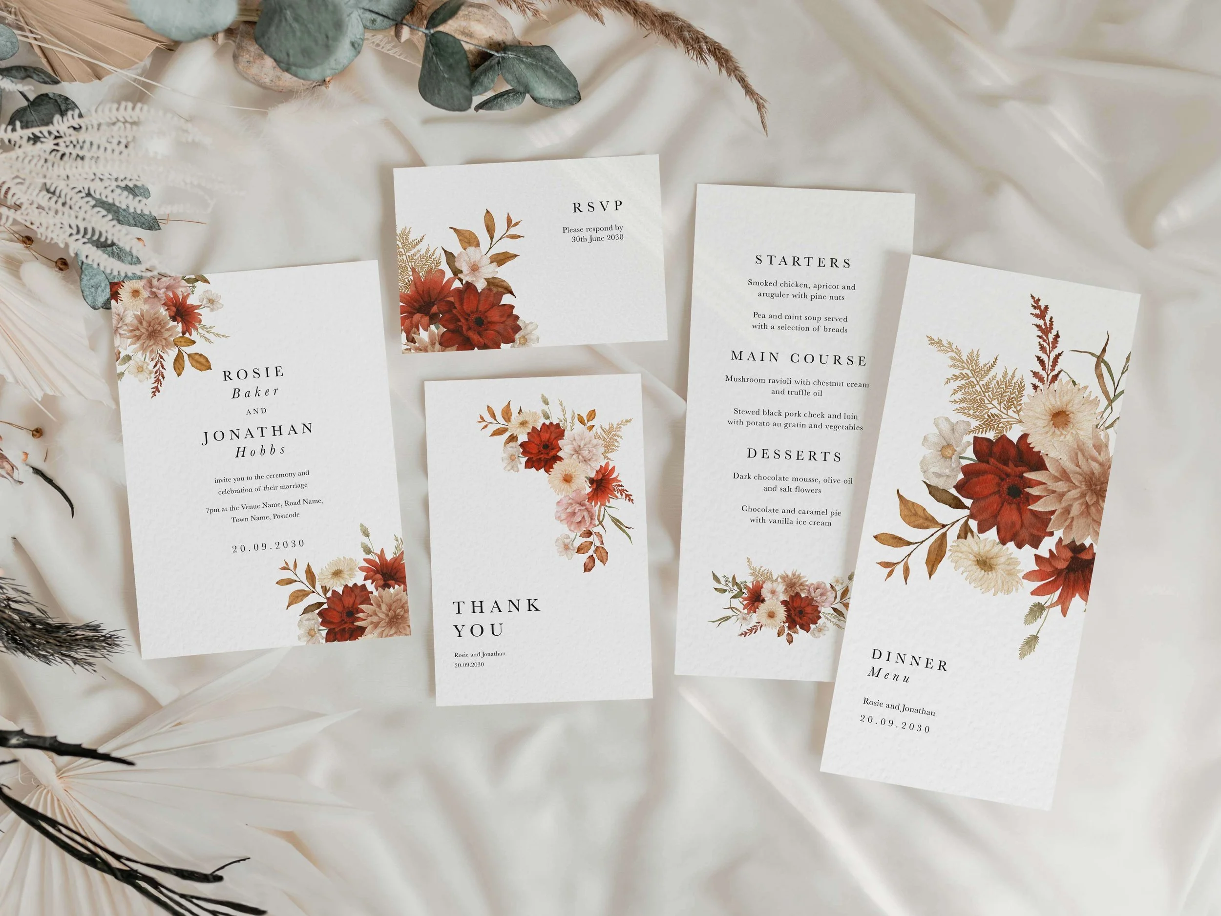 Full Rustic wedding stationery suite flat lay showing invitations, RSVP cards and coordinating pieces with bold crimson dahlia and cream floral design