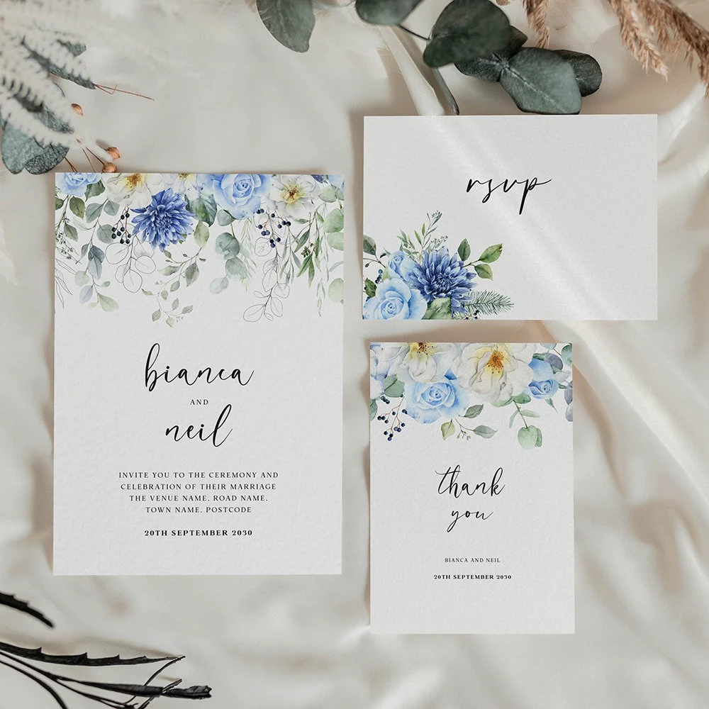 Blue Floral Wreath wedding invitation with soft blue and white florals arranged in a circular wreath, accented with greenery for a fresh, elegant look.