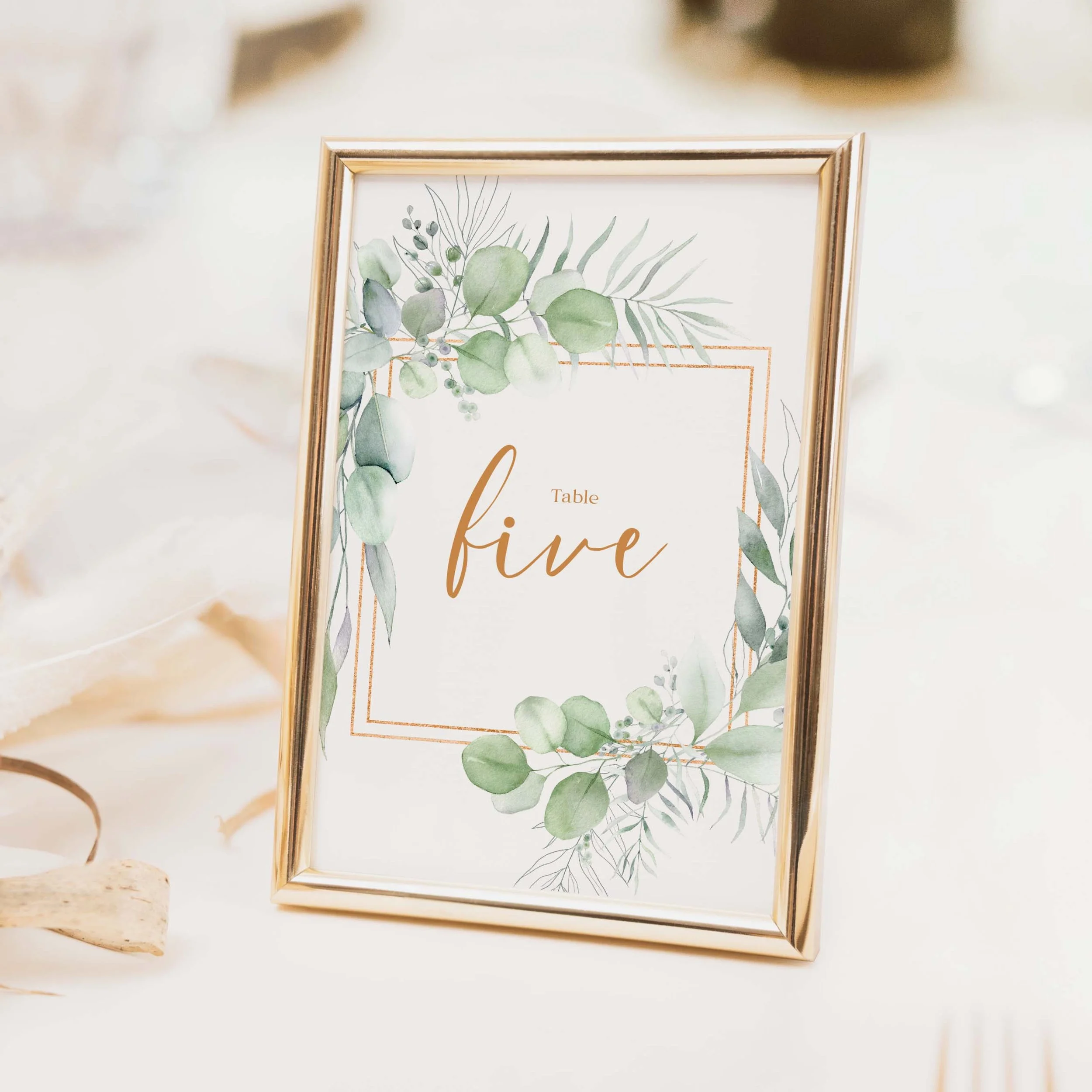 Eucalyptus Frame wedding table number with botanical foliage border frame and copper calligraphy script typography on luxury off-white card