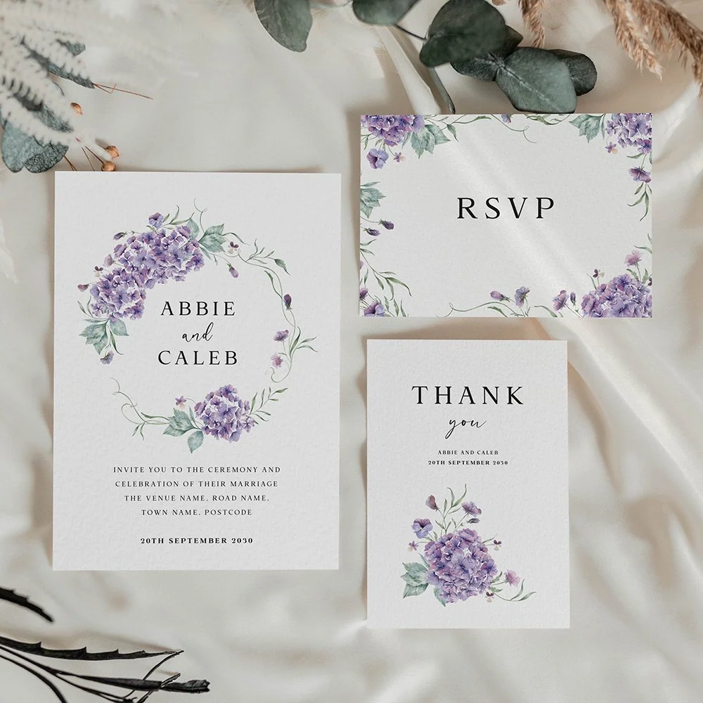 Hydrangea Collection wedding stationery set featuring flat invitation, RSVP card, and thank you card with lilac and mauve hydrangeas and sage green leaves.