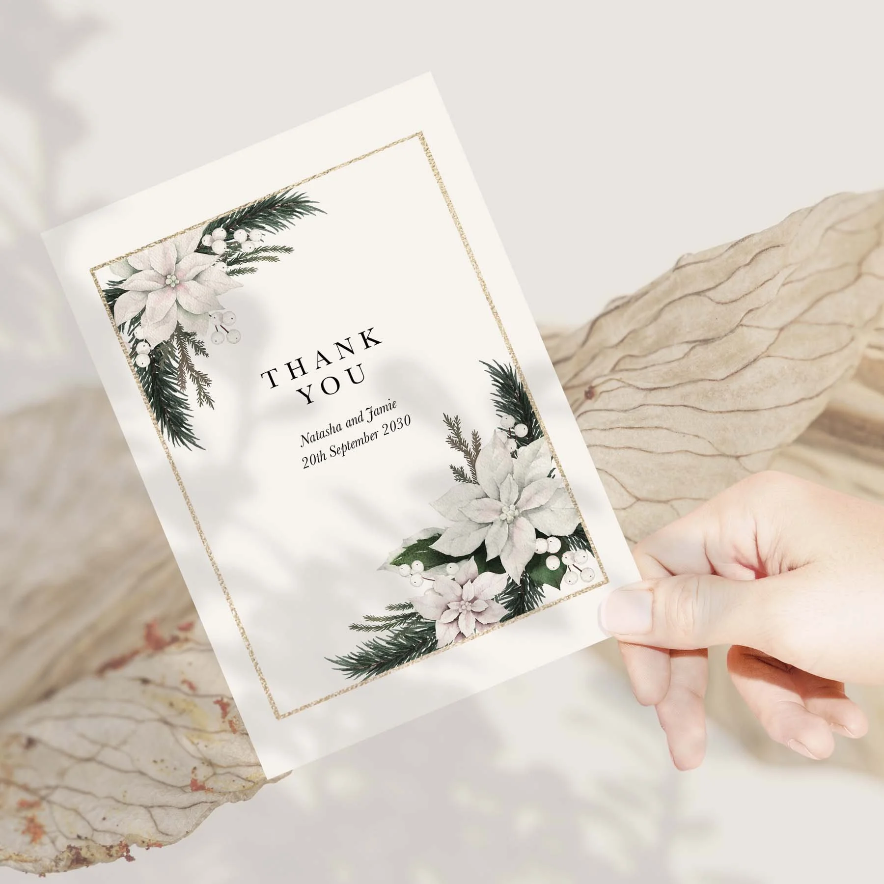 Hand holding a White Poinsettia wedding thank you card