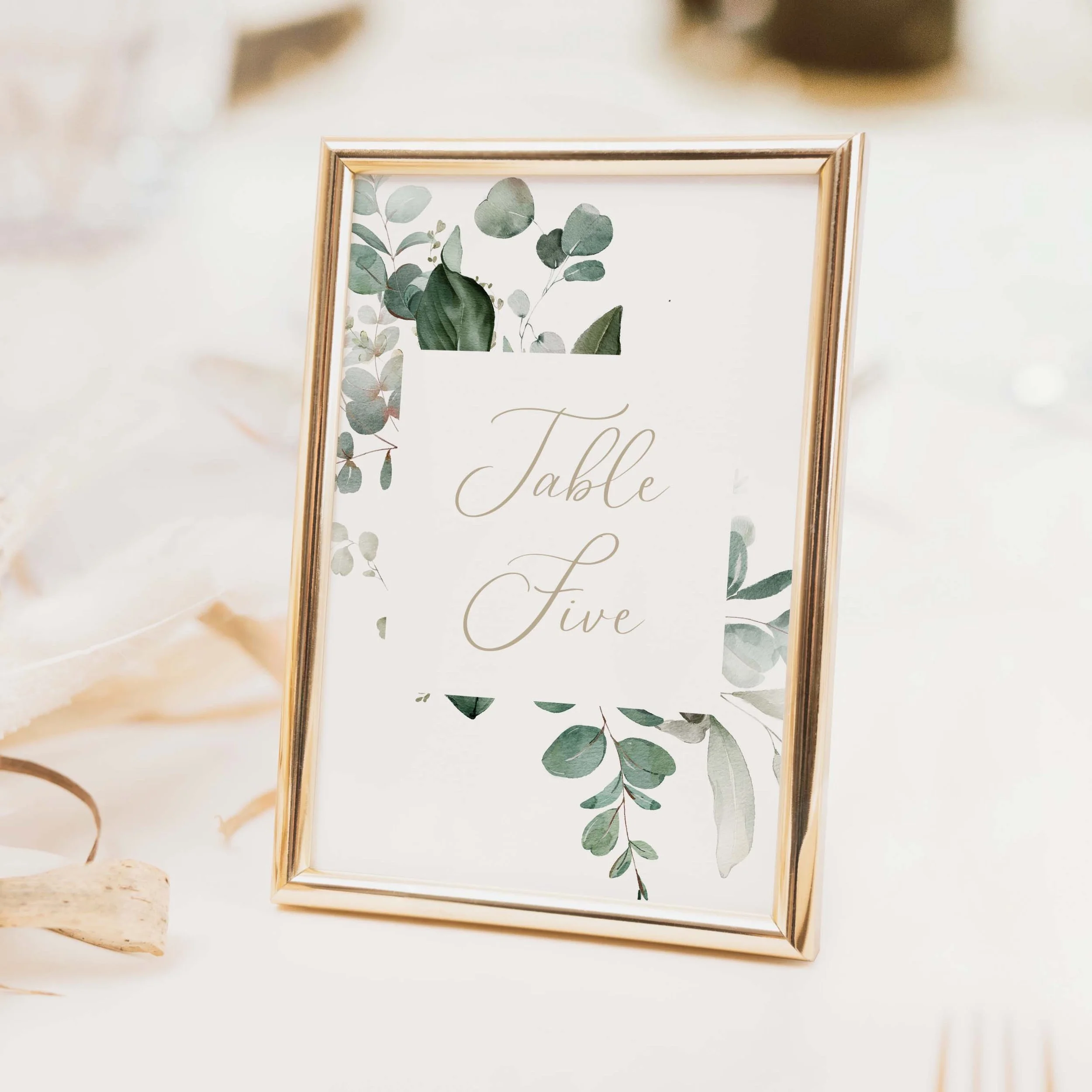 Emerald Forest greenery wedding table number with deep green foliage illustration and calligraphy font, printed on luxury off-white card