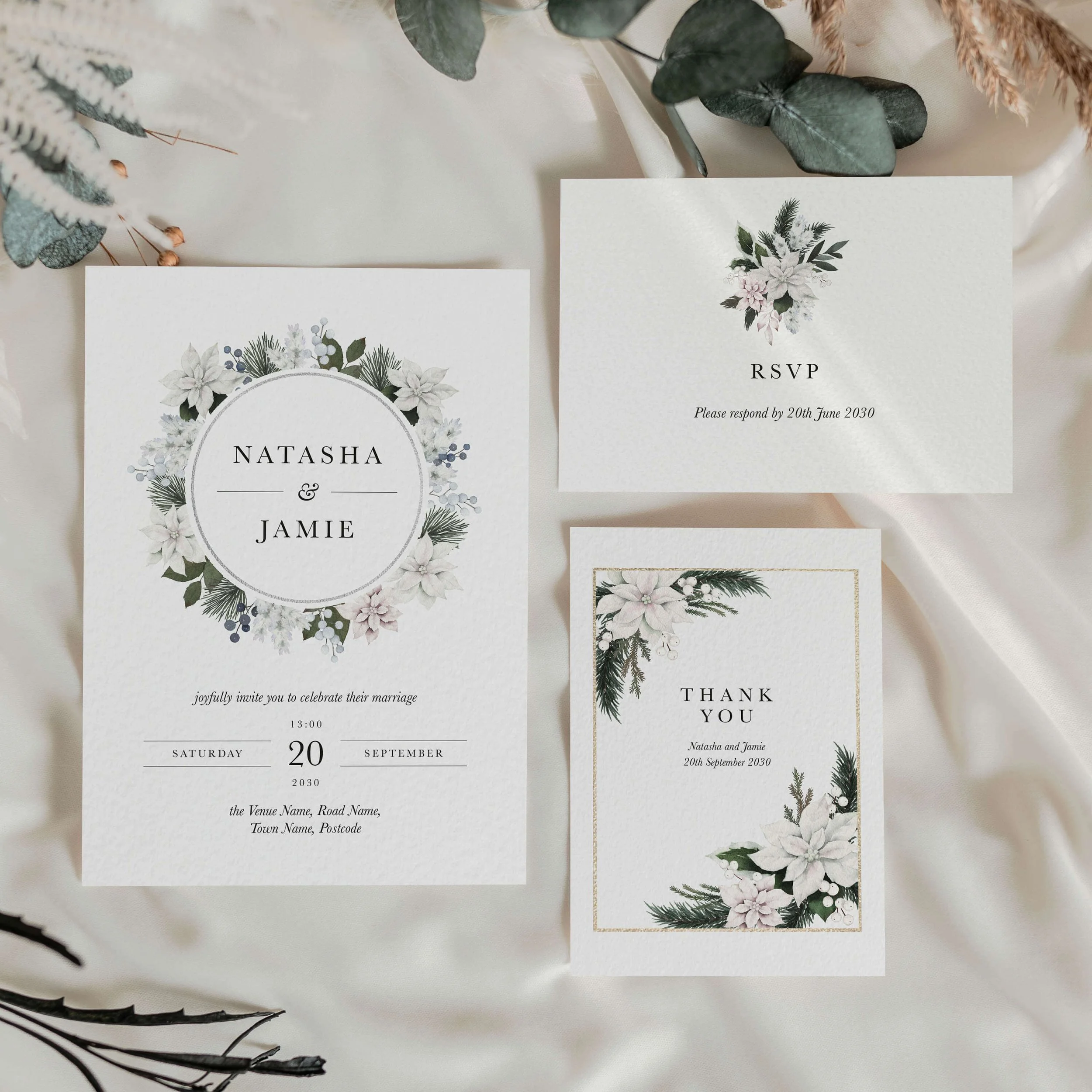 The Winter Frost wedding stationery collection showing invitation and thank you card with an elegant white poinsettia botanical wreath in a circular frame