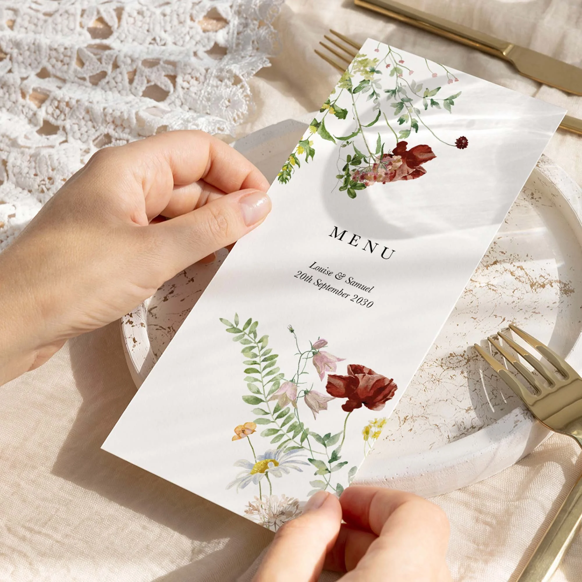 Hand holding a Meadow wedding breakfast menu card with a delicate rustic wildflower design