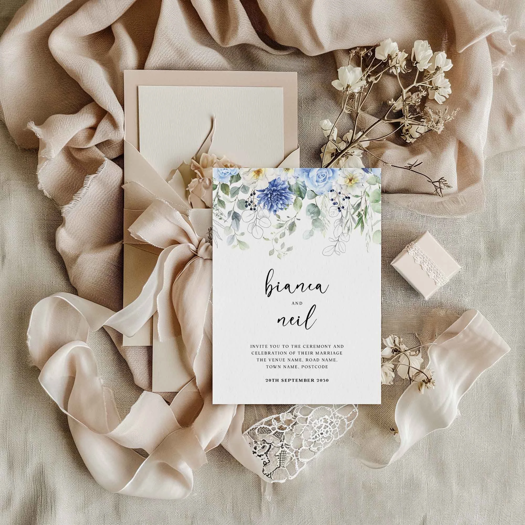 Blue Floral Drop wedding invitation styled in a flat lay environment with wedding props