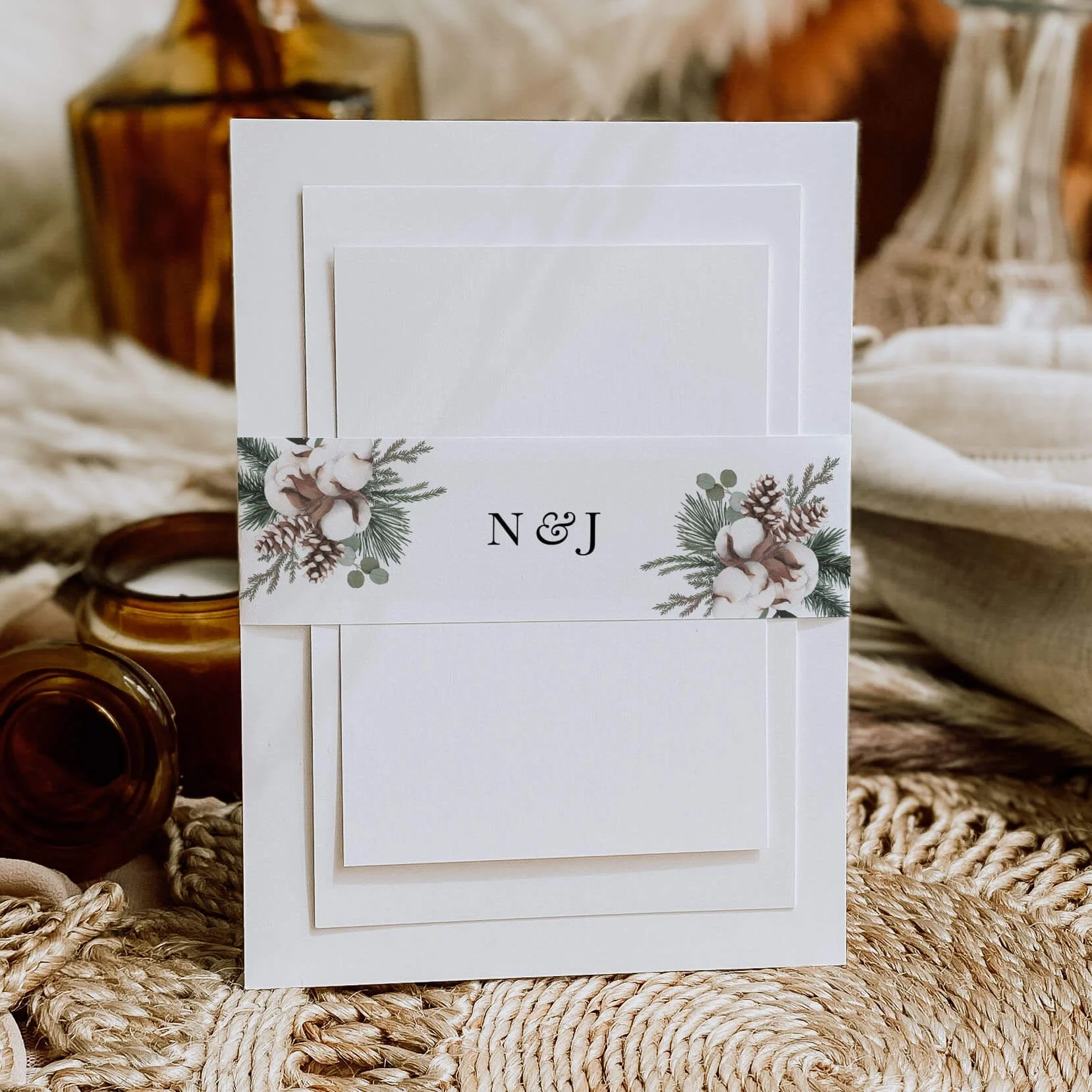 Woodland personalised wedding belly bands with pine cone cotton stem and pine branch botanical illustration wrapped around wedding invitations