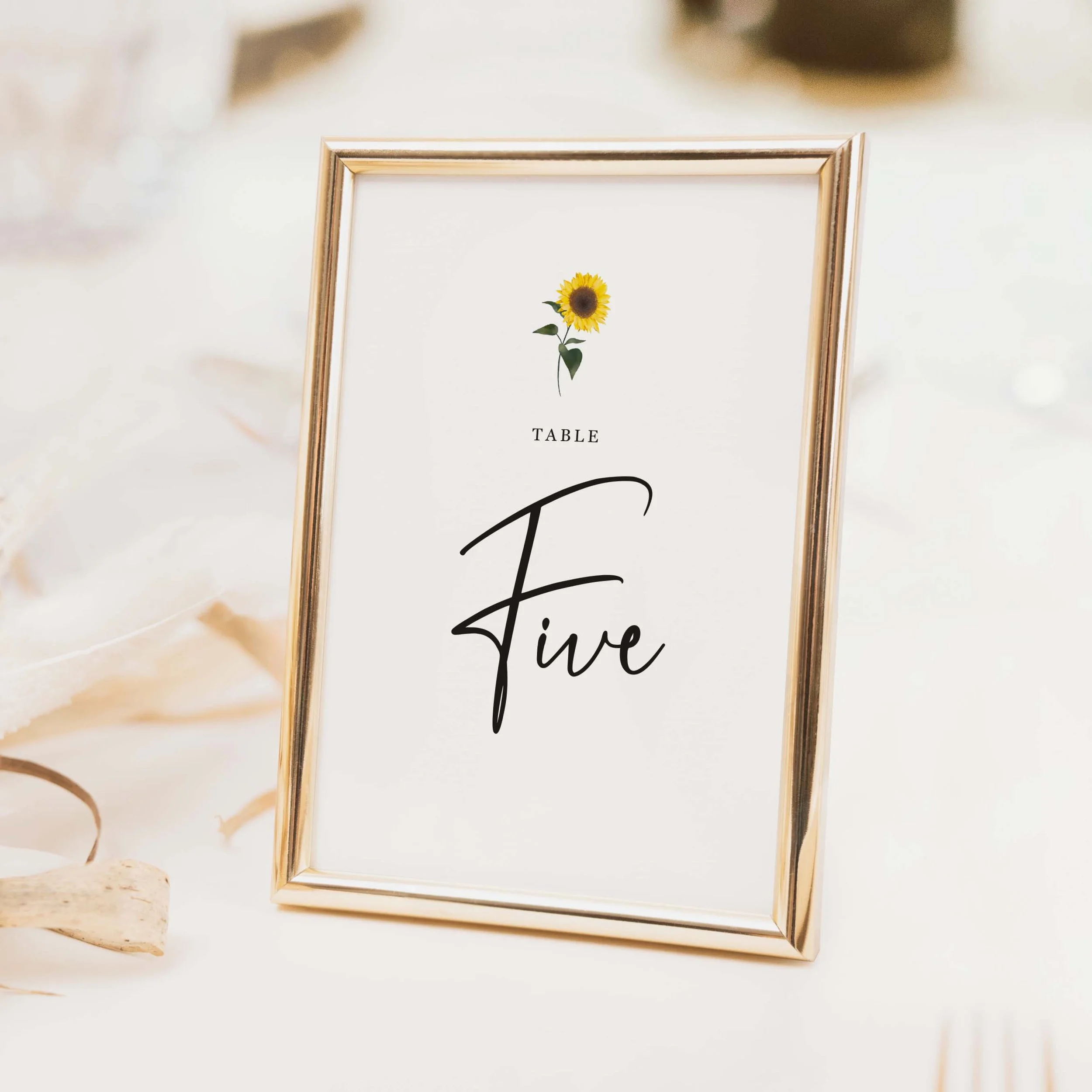Sunflower wedding table number with delicate sunflower illustration and flowing calligraphy script typography on luxury off-white card