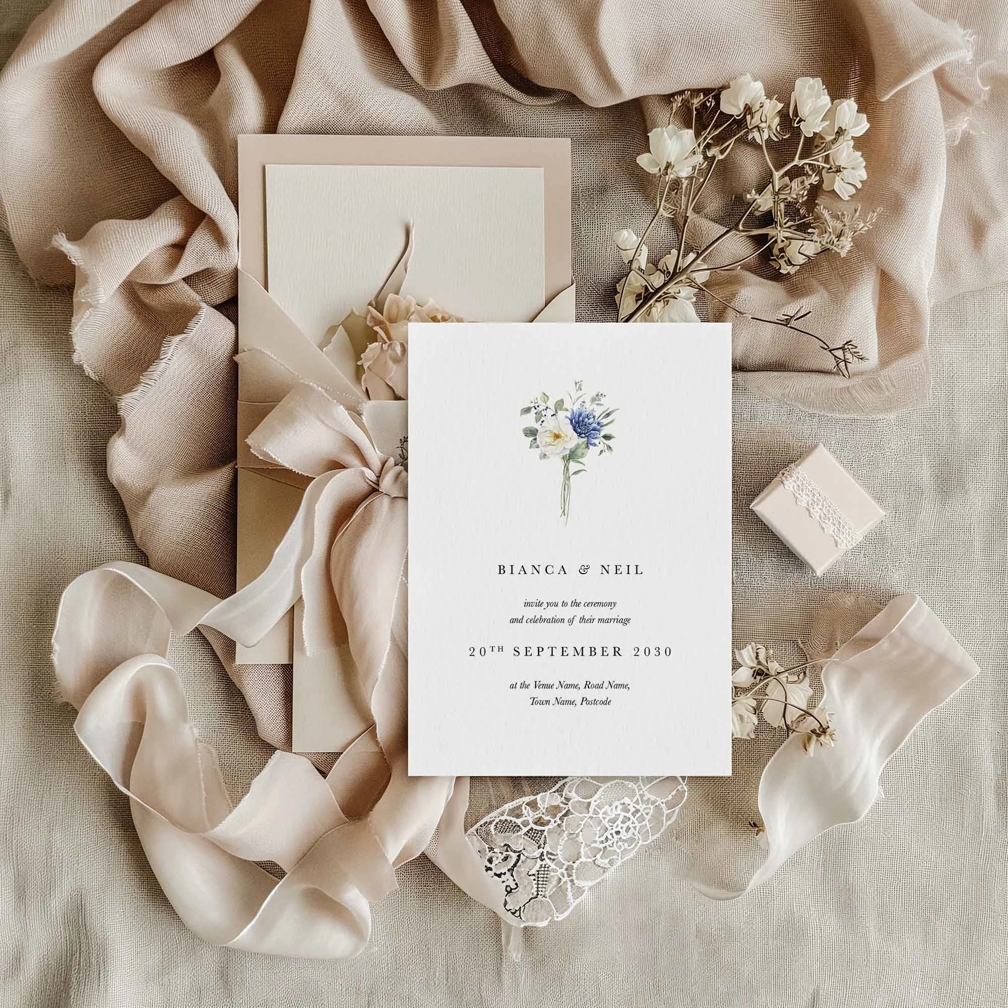 Blue Floral Bouquet wedding invitation styled in a flat lay environment with wedding props