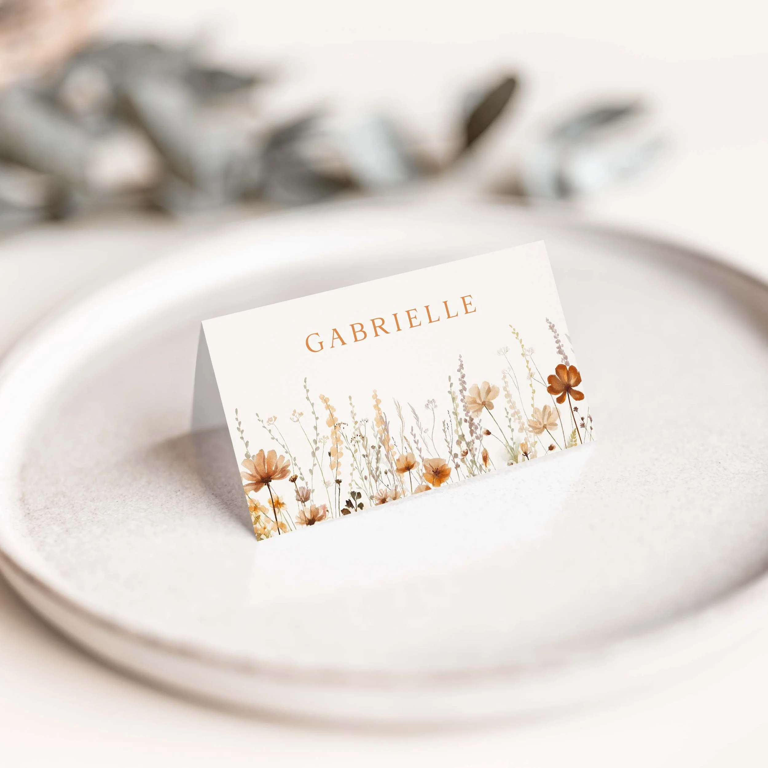 Autumn wedding place card with warm wildflower border along the bottom