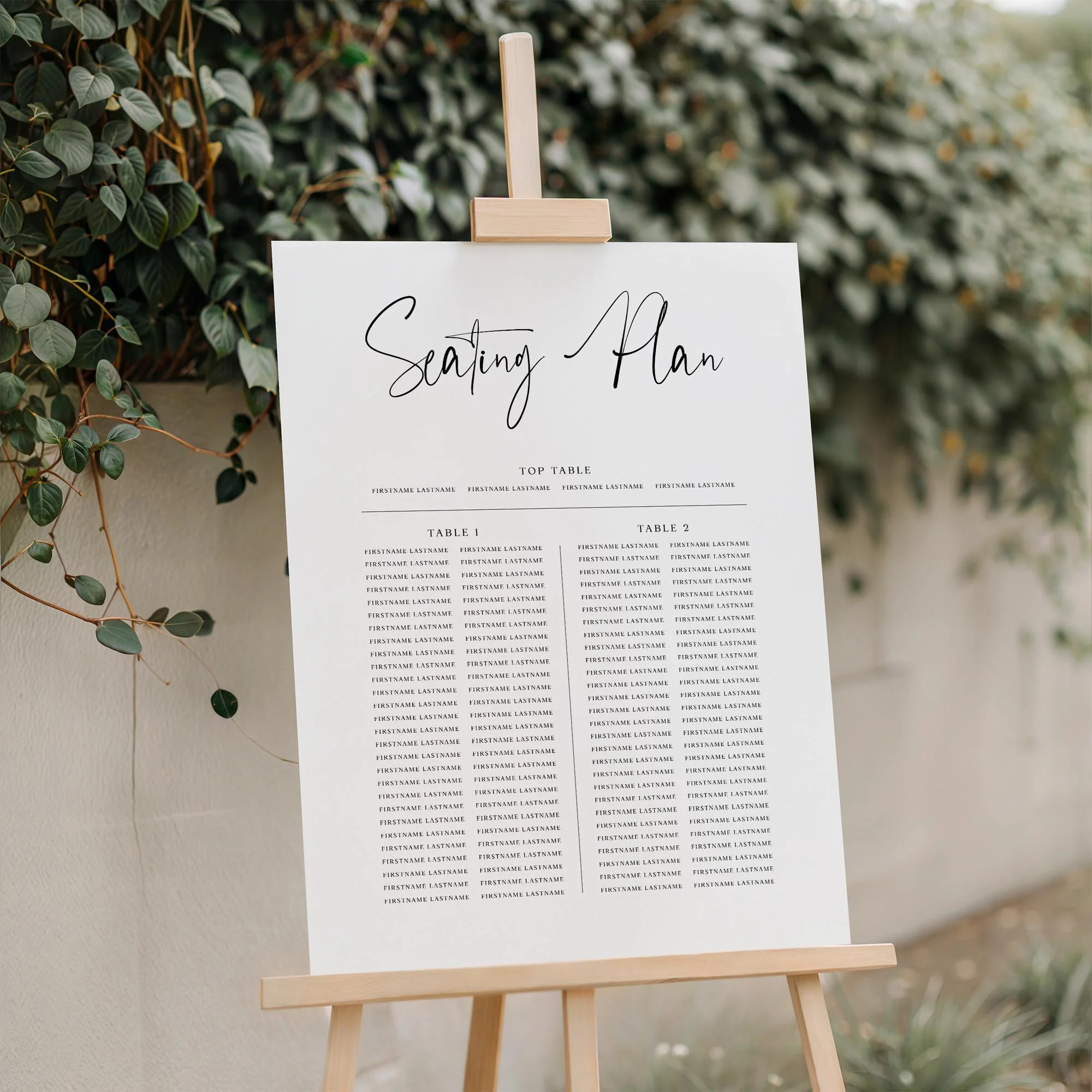 Close-up of the Black and White Signature Style Calligraphy wedding seating plan board with trestle tables displayed outdoors
