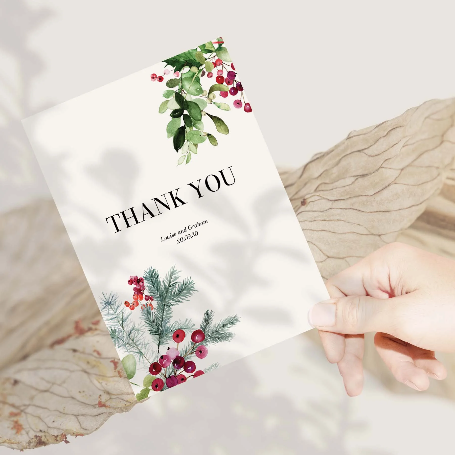Hand holding a Green Winter Leaves and Red Berries wedding thank you card