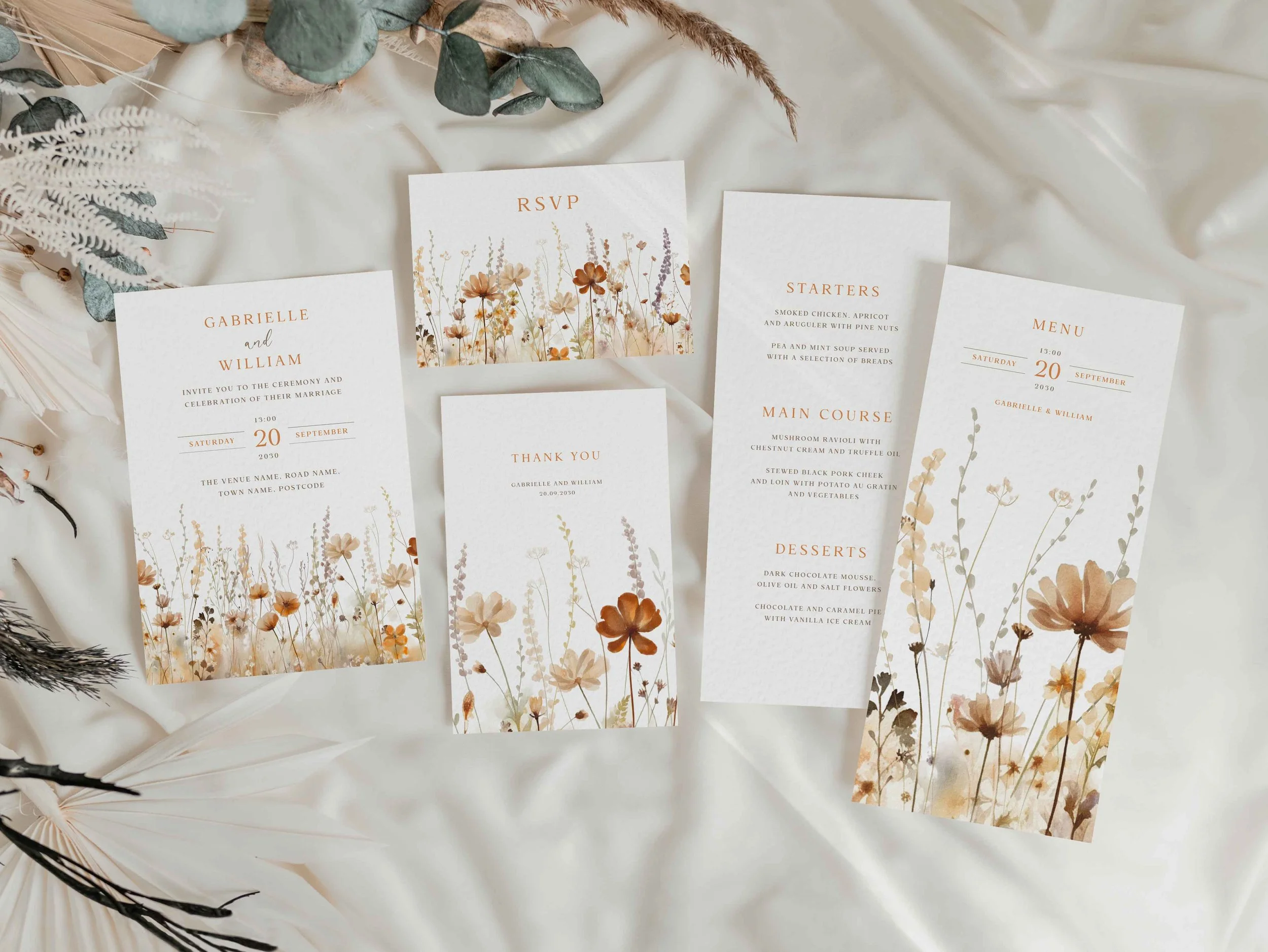 Full Field Harvest wedding stationery suite flat lay showing invitations, RSVP cards and coordinating pieces with an autumn wildflower meadow border