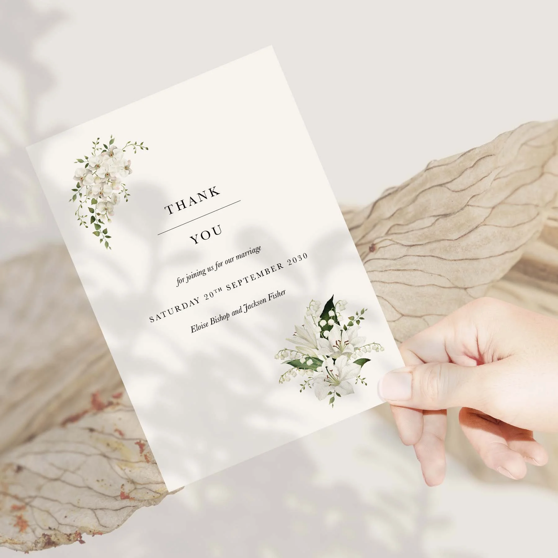 Hand holding a White Lily wedding thank you card