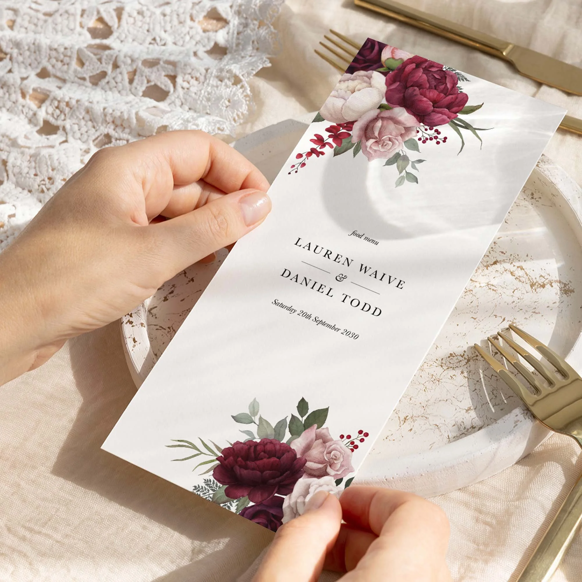 Hand holding Burgundy and Pink Floral wedding menu card showing size and printed design details