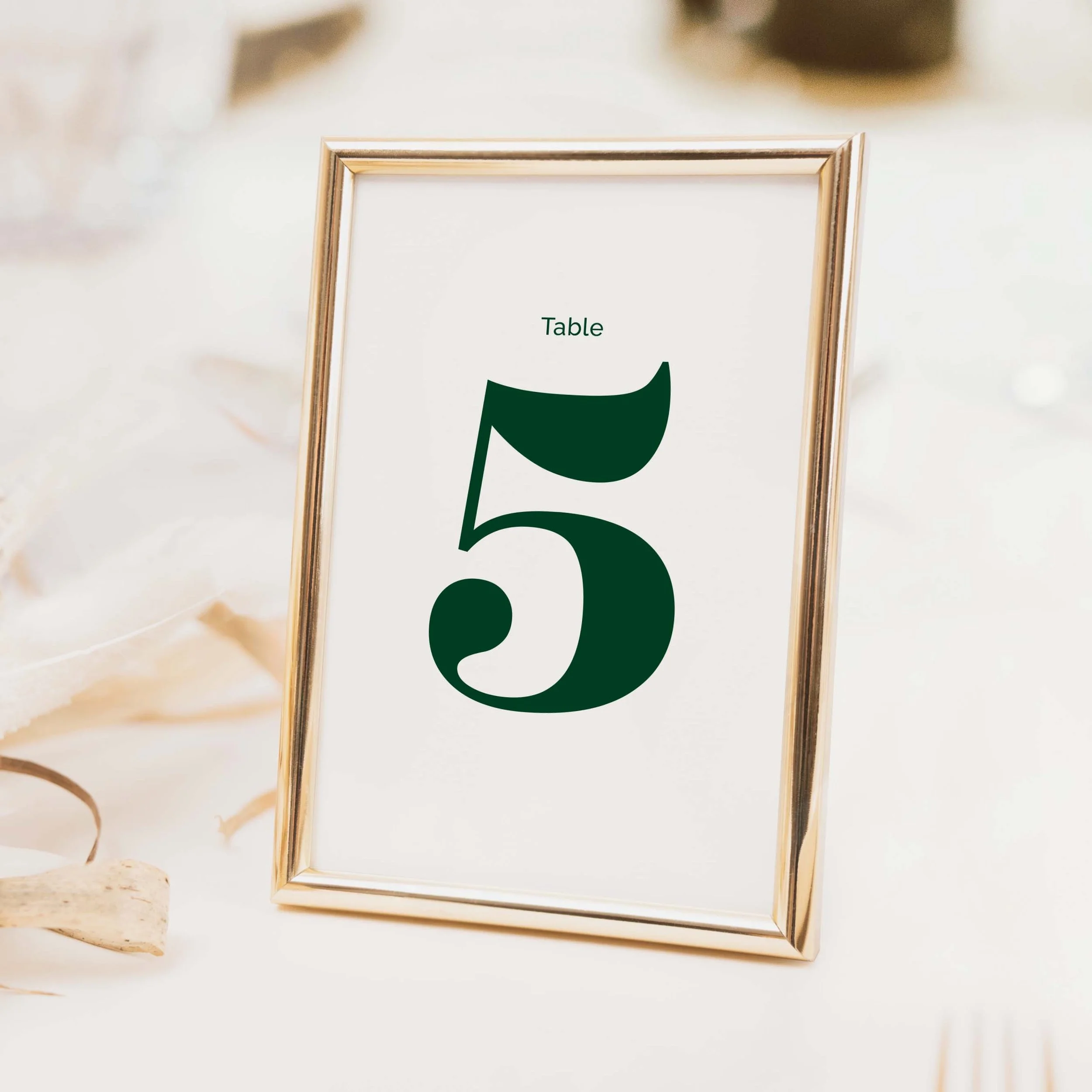 Forest green typographic wedding table number with large bold green numeral and clean serif lettering on luxury off-white card