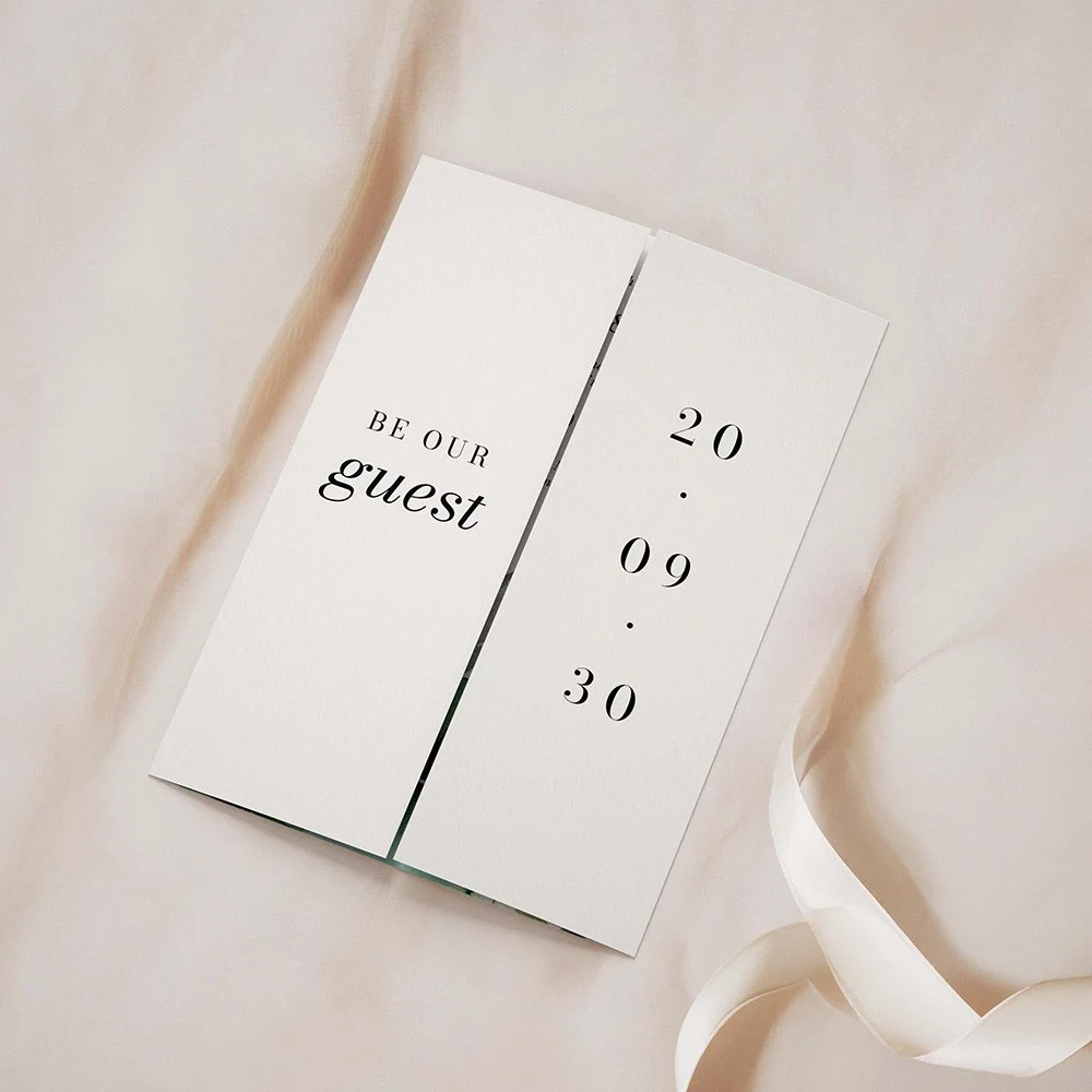 Wilderness Collection gatefold wedding invitation closed, featuring a watercolour landscape of a forest, lake, and mountains in earthy green tones