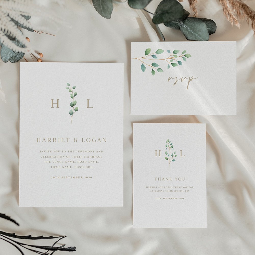 Minimal wedding stationery featuring a eucalyptus branch between monogram initials, with simple gold serif text on a cream background.