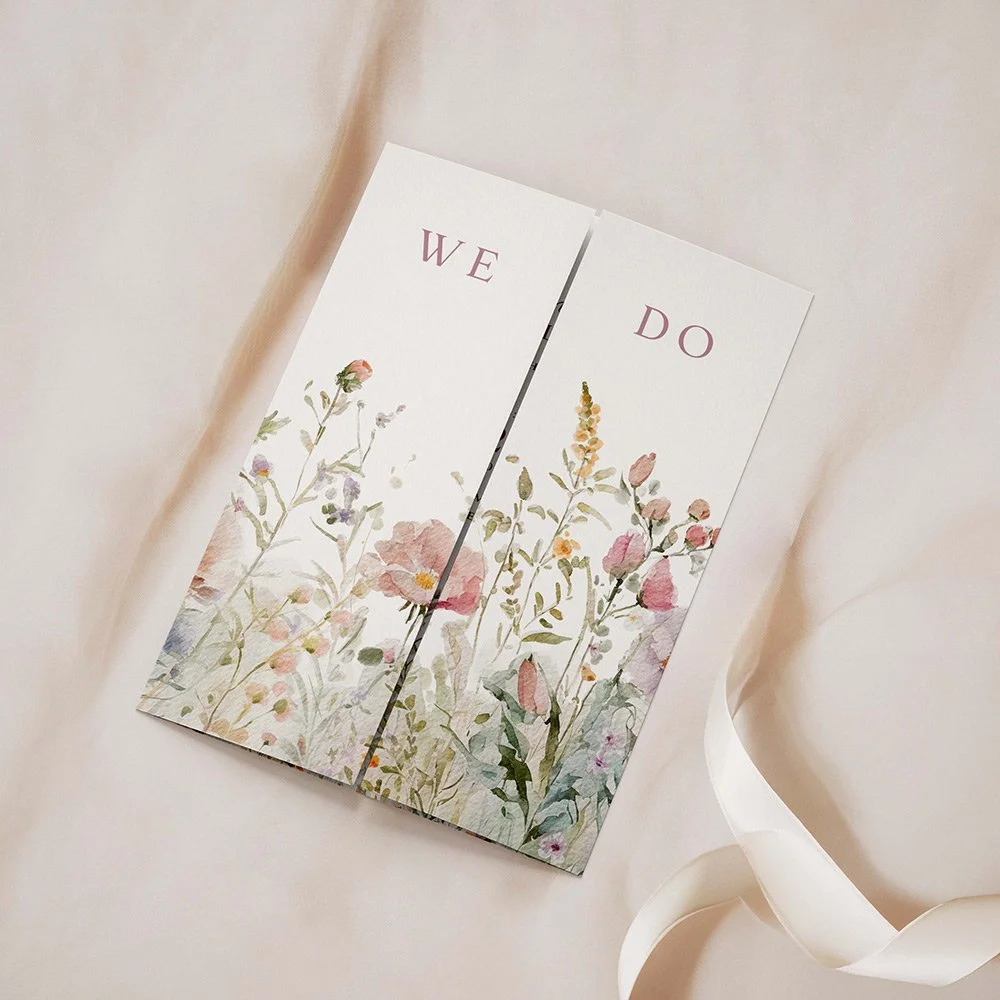 Field Collection Powder gatefold wedding invitation closed, featuring blush pink and dusty mauve wildflowers with elegant serif typography