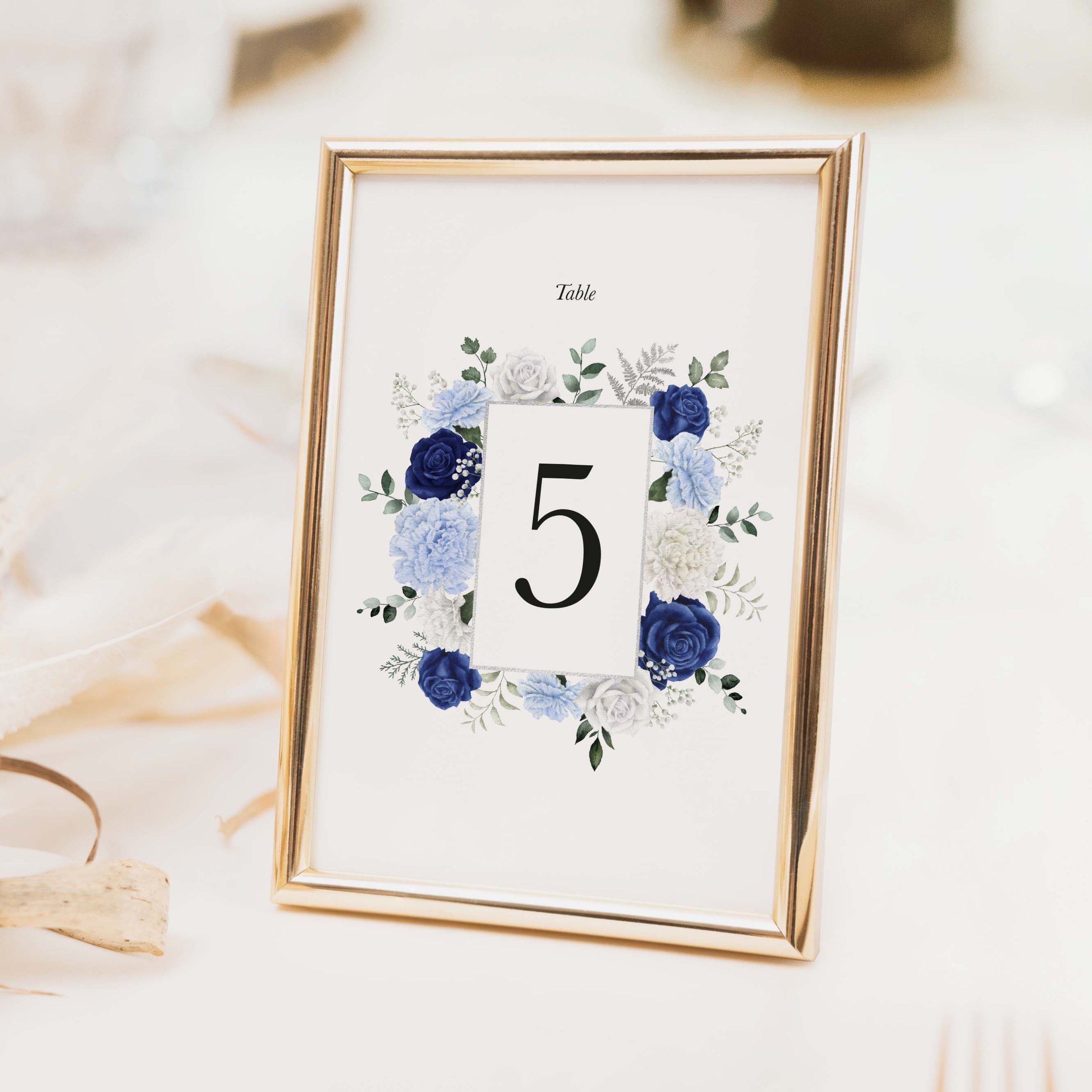 Royal wedding table number with navy blue and white botanical floral illustration and large bold numeral on luxury off-white card