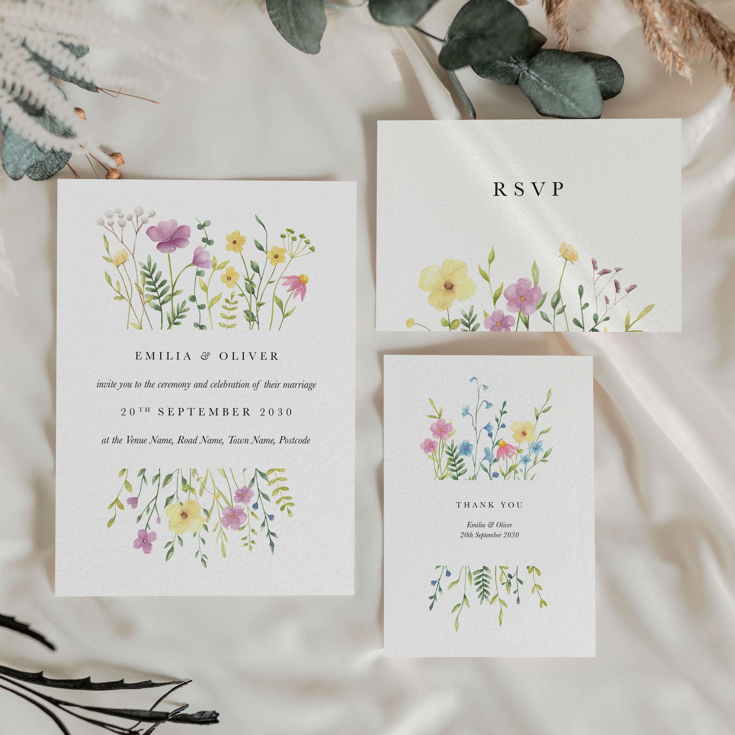 Wildflower wedding stationery suite flat lay showing invitations, RSVP cards and coordinating pieces with colourful wildflowers