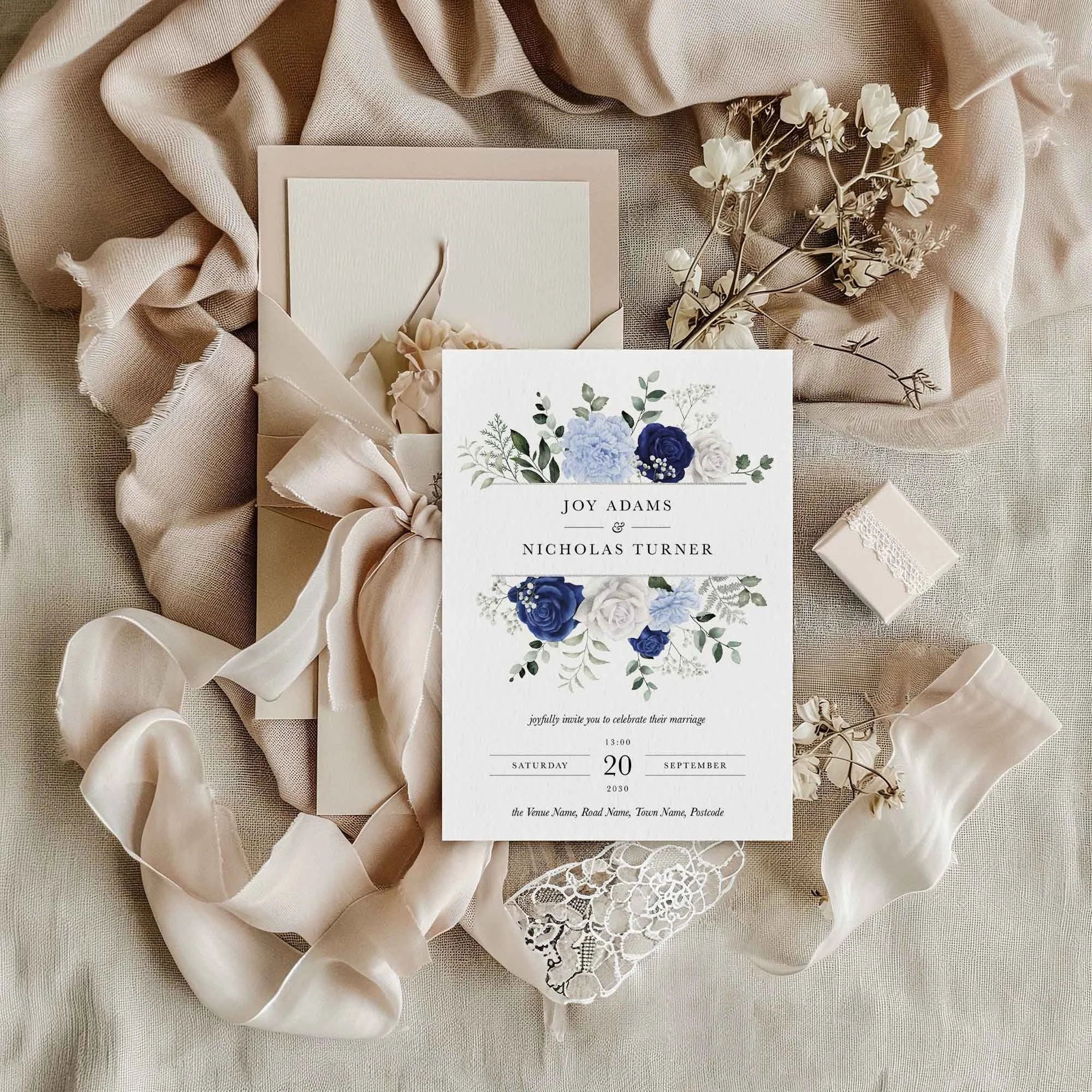 Blue and White Floral Frame wedding invitation styled in a flat lay environment with wedding props