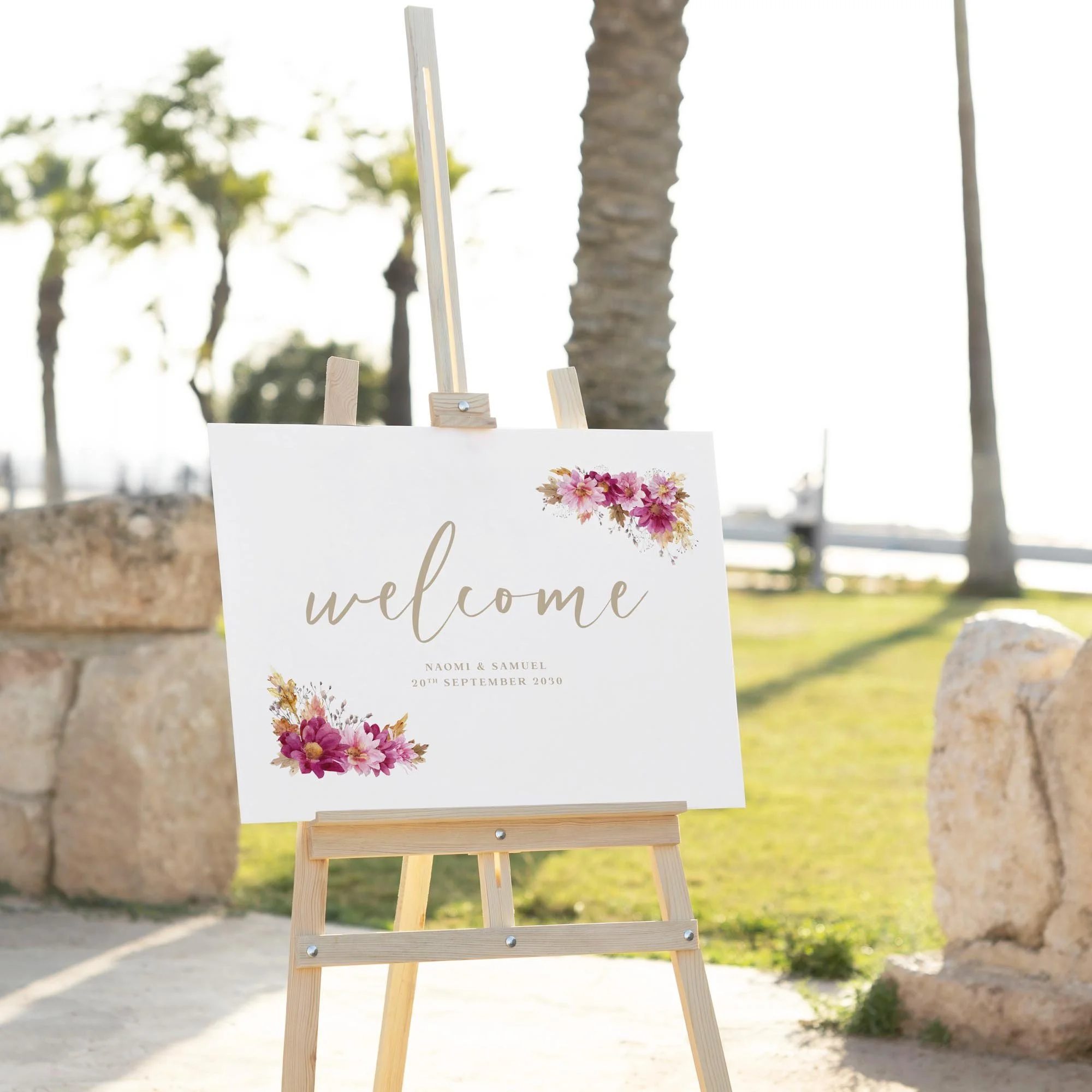 Dark Pink Chrysanthemum wedding welcome sign displayed outdoors at a wedding venue on an easel