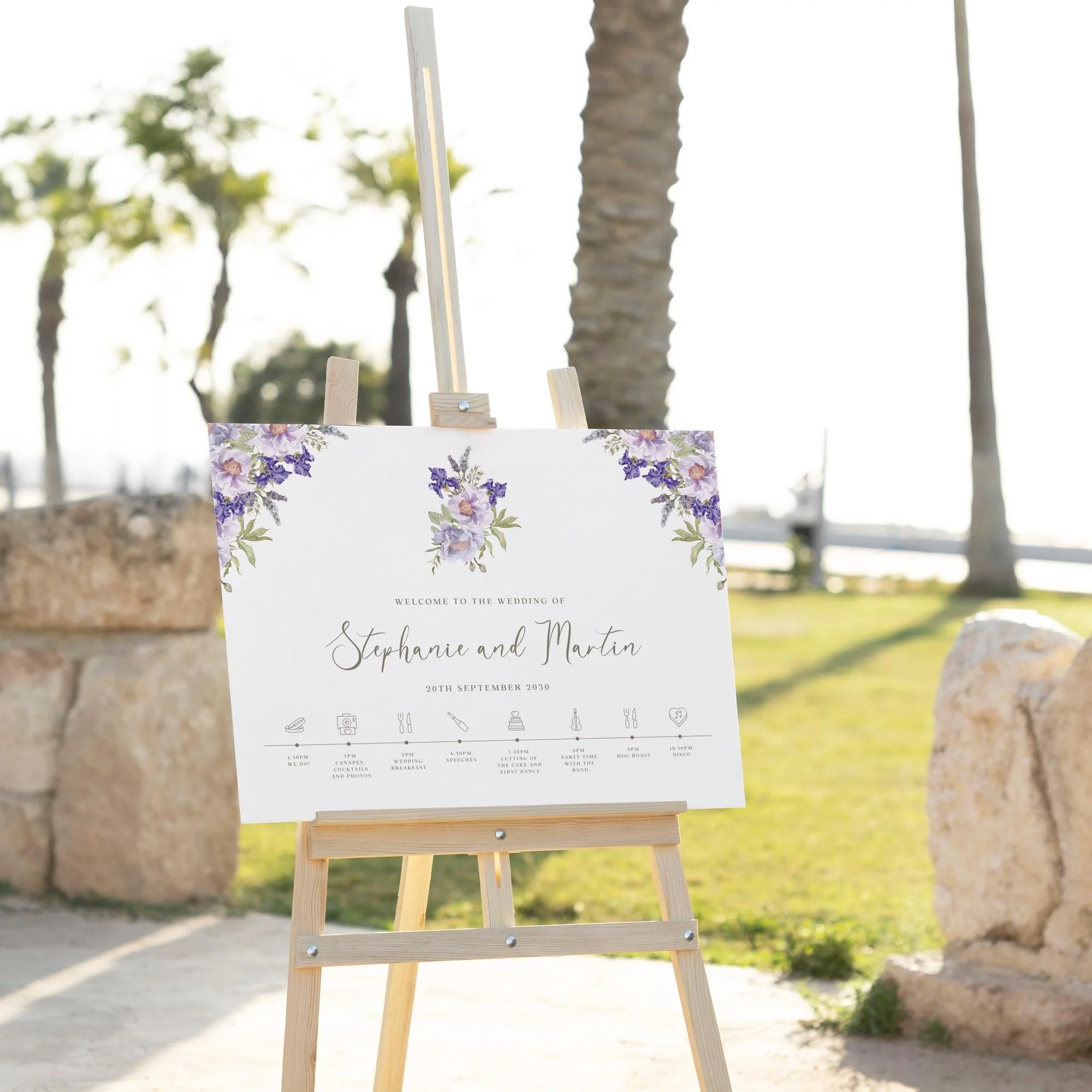 Purple Floral Lilac wedding welcome sign displayed outdoors at a wedding venue on an easel