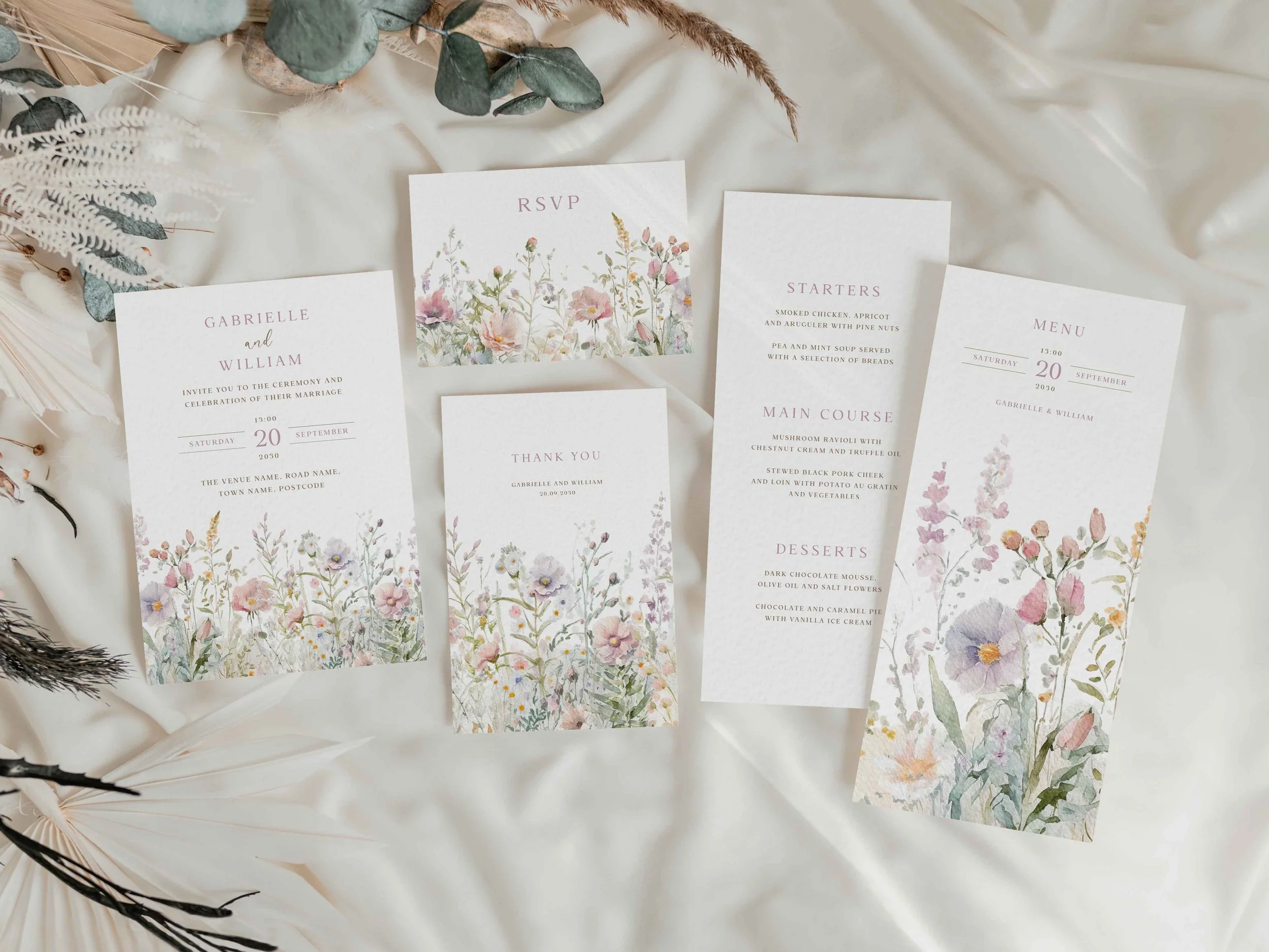 Full Field Powder wedding stationery suite flat lay showing invitations, RSVP cards and coordinating pieces with pink pastel wildflower design
