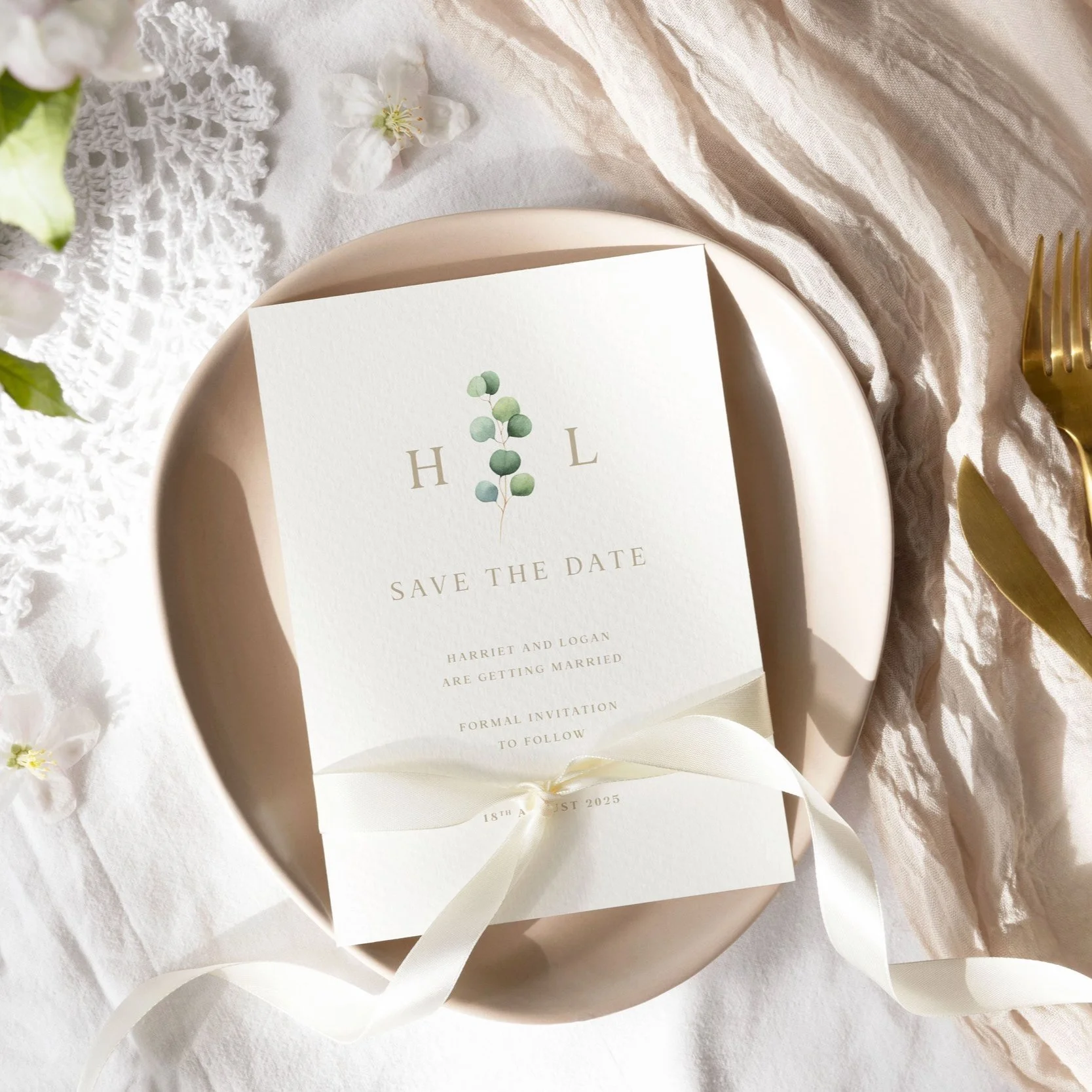 Minimal Save the Date card featuring a eucalyptus branch between monogram initials, with simple gold serif text on a cream background.