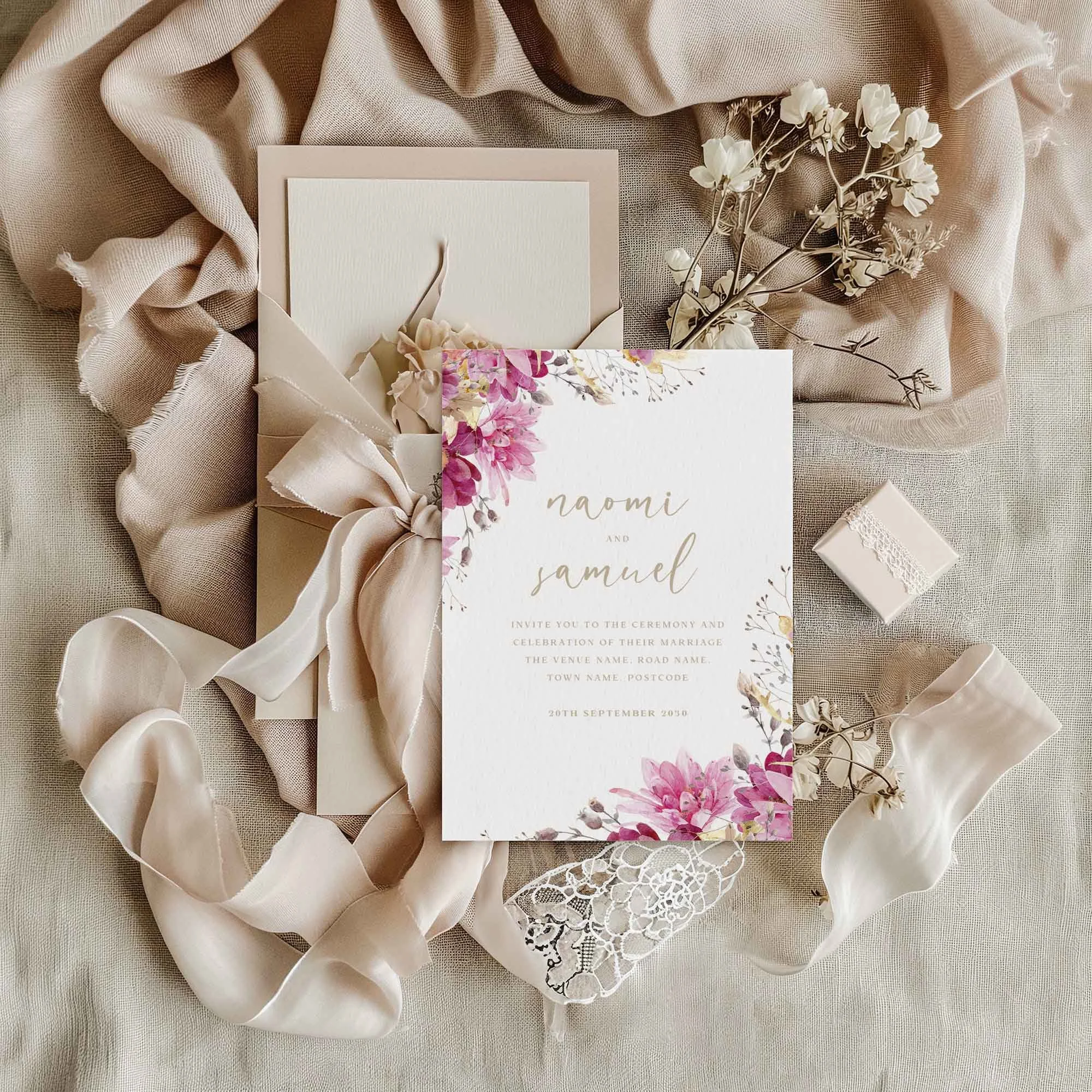 Pink and Gold Floral wedding invitation styled in a flat lay environment with wedding props