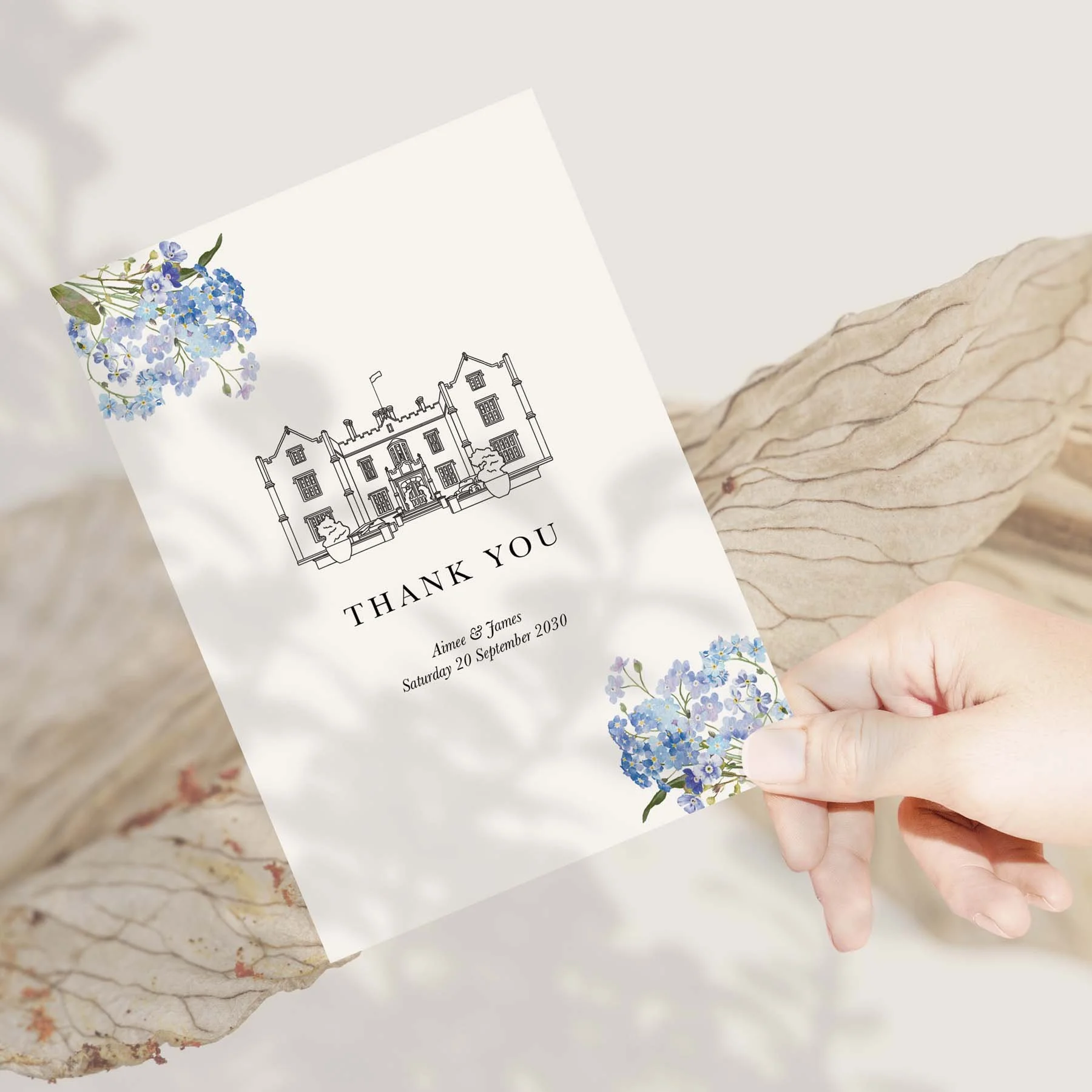 Hand holding a Bespoke Venue Illustration and Florals wedding thank you card