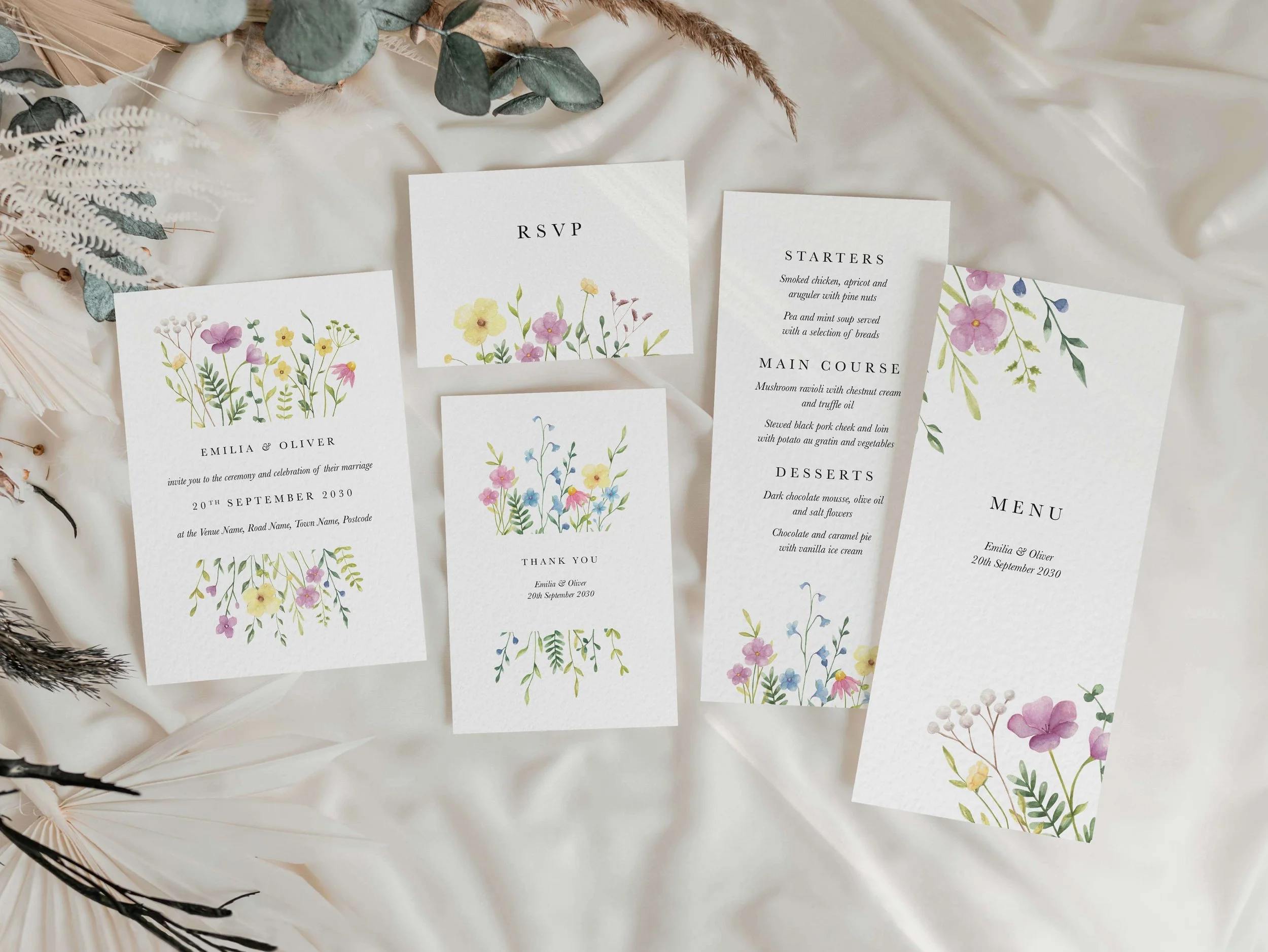 Full Wildflower wedding stationery suite flat lay showing invitations, RSVP cards and coordinating pieces with colourful wildflower design