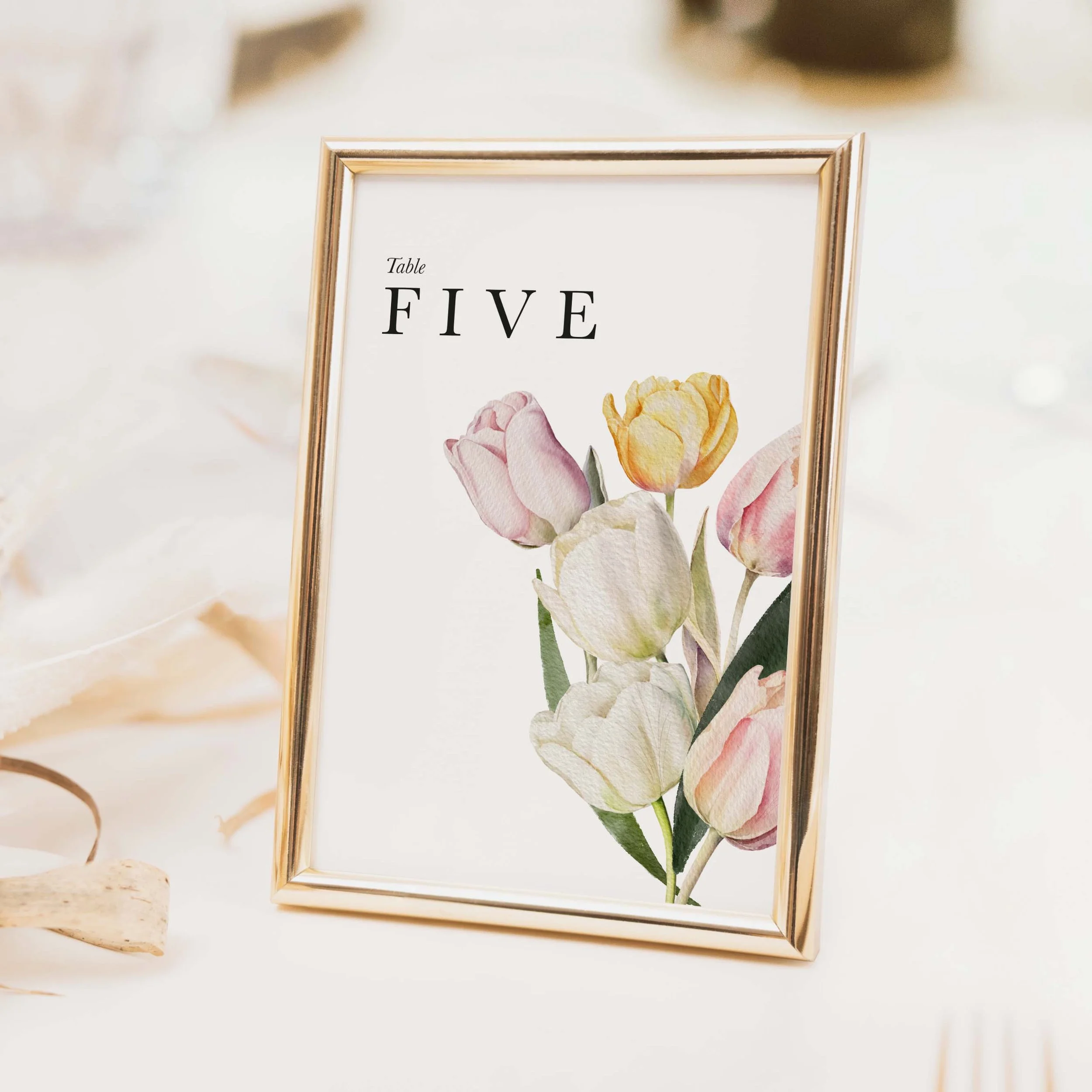 Tulip wedding table number with soft pink watercolour tulip illustration and flowing script typography for spring weddings on luxury off-white card