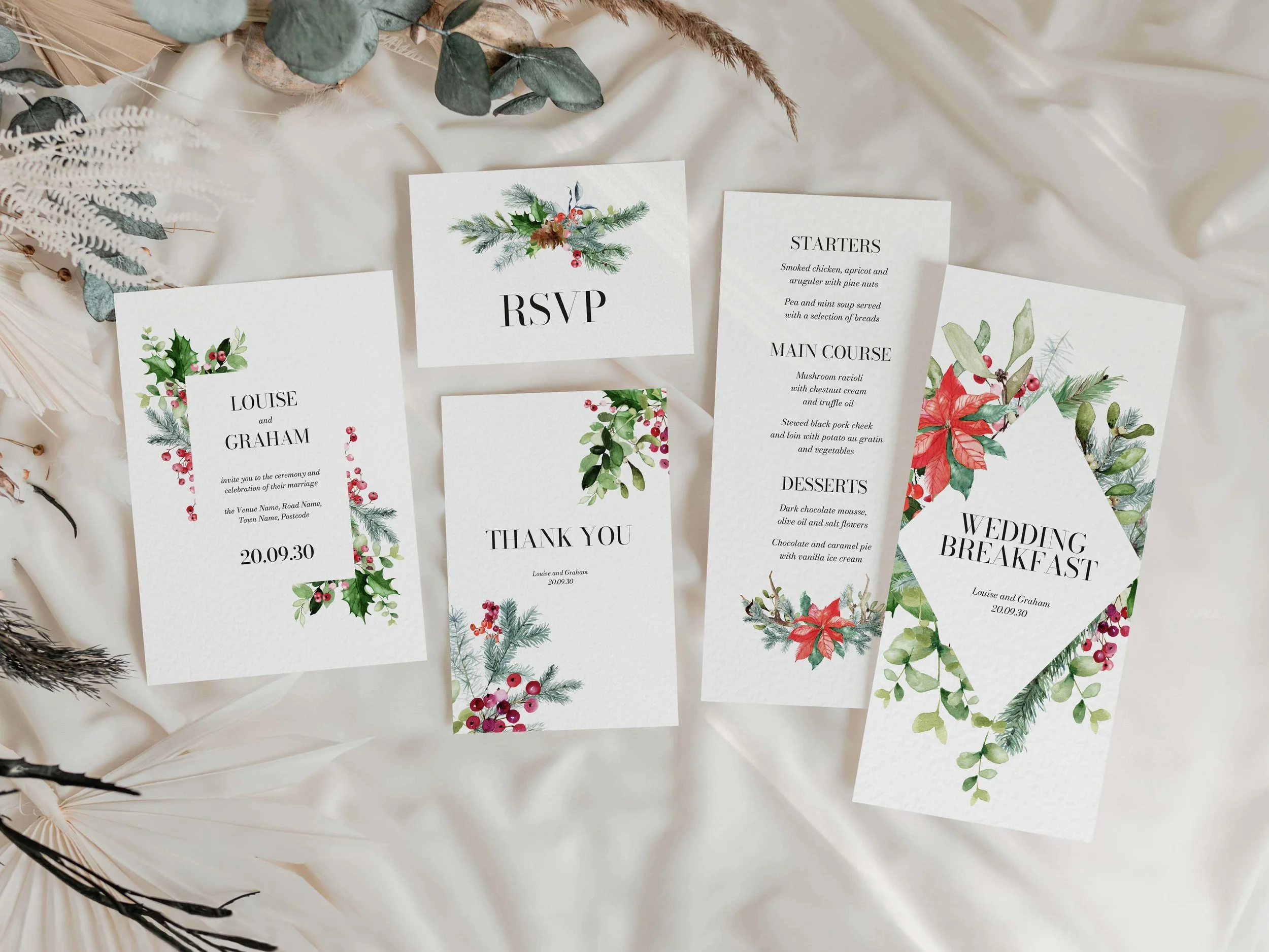 Full Festive wedding stationery suite flat lay showing invitations, RSVP cards and coordinating pieces with a holly and red berry Christmas botanical design