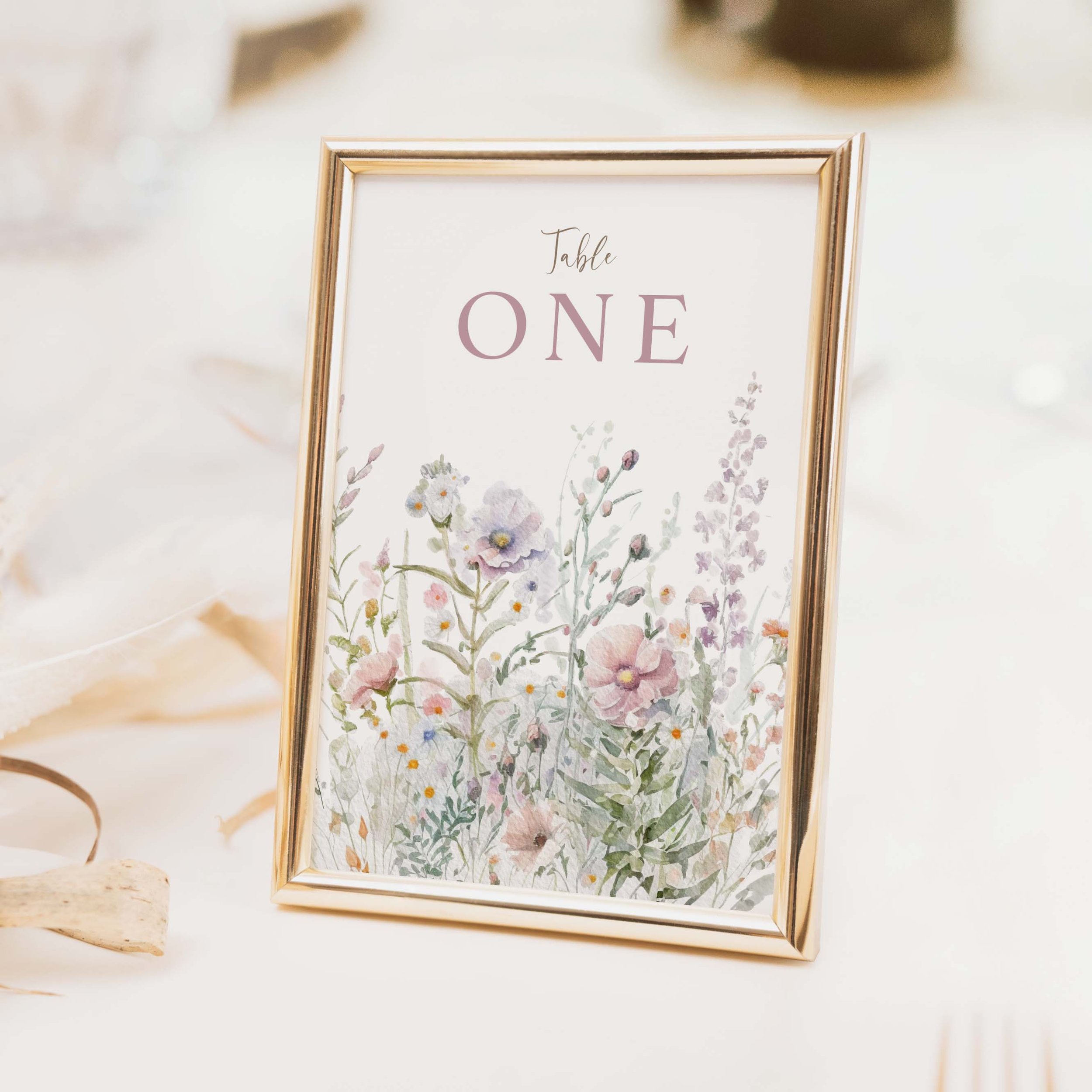 Field Powder wedding table number with soft pink and blush wildflower meadow illustration and clean typography on luxury off-white card