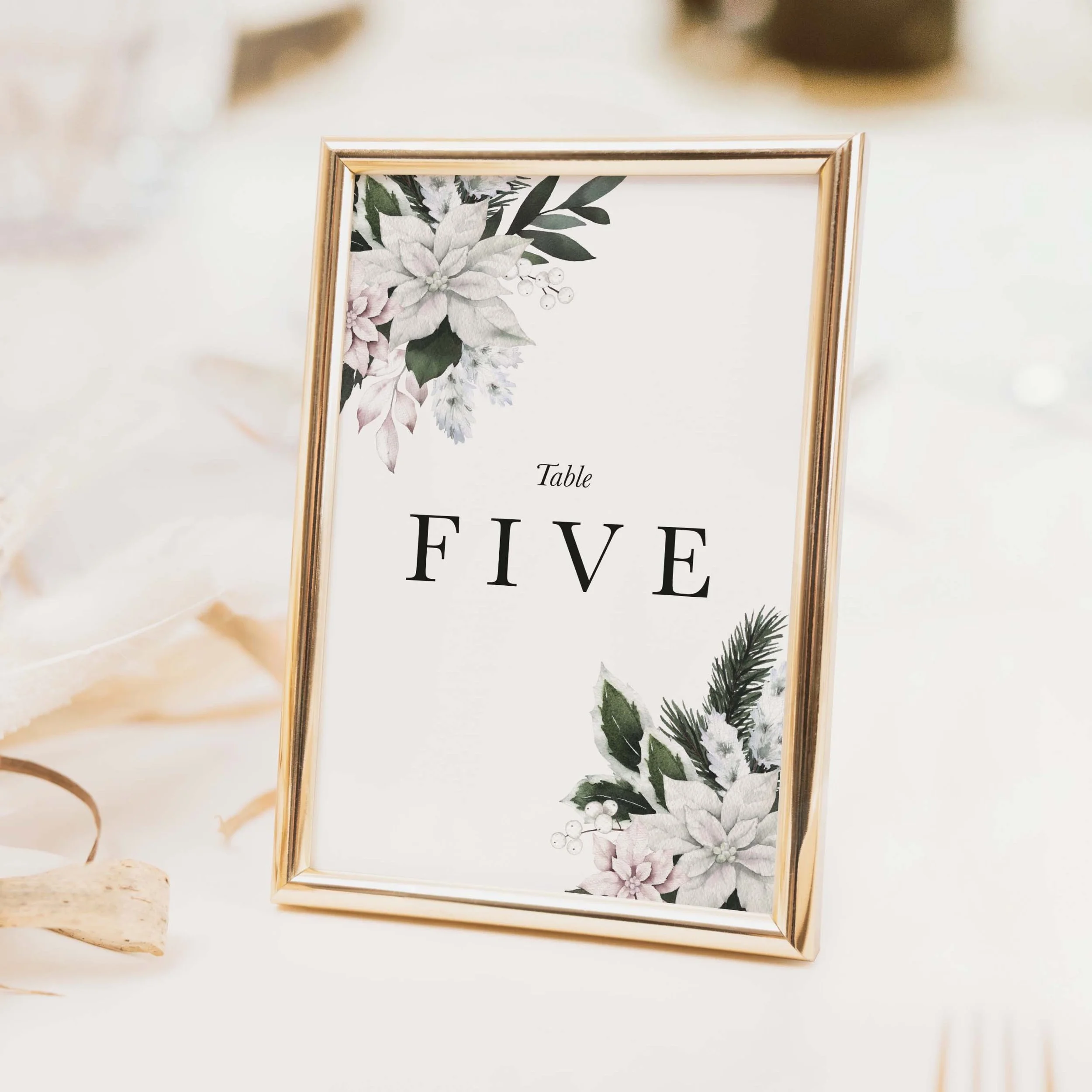 Winter Frost wedding table number with dark moody winter botanical foliage and bold clean typography on luxury off-white textured card