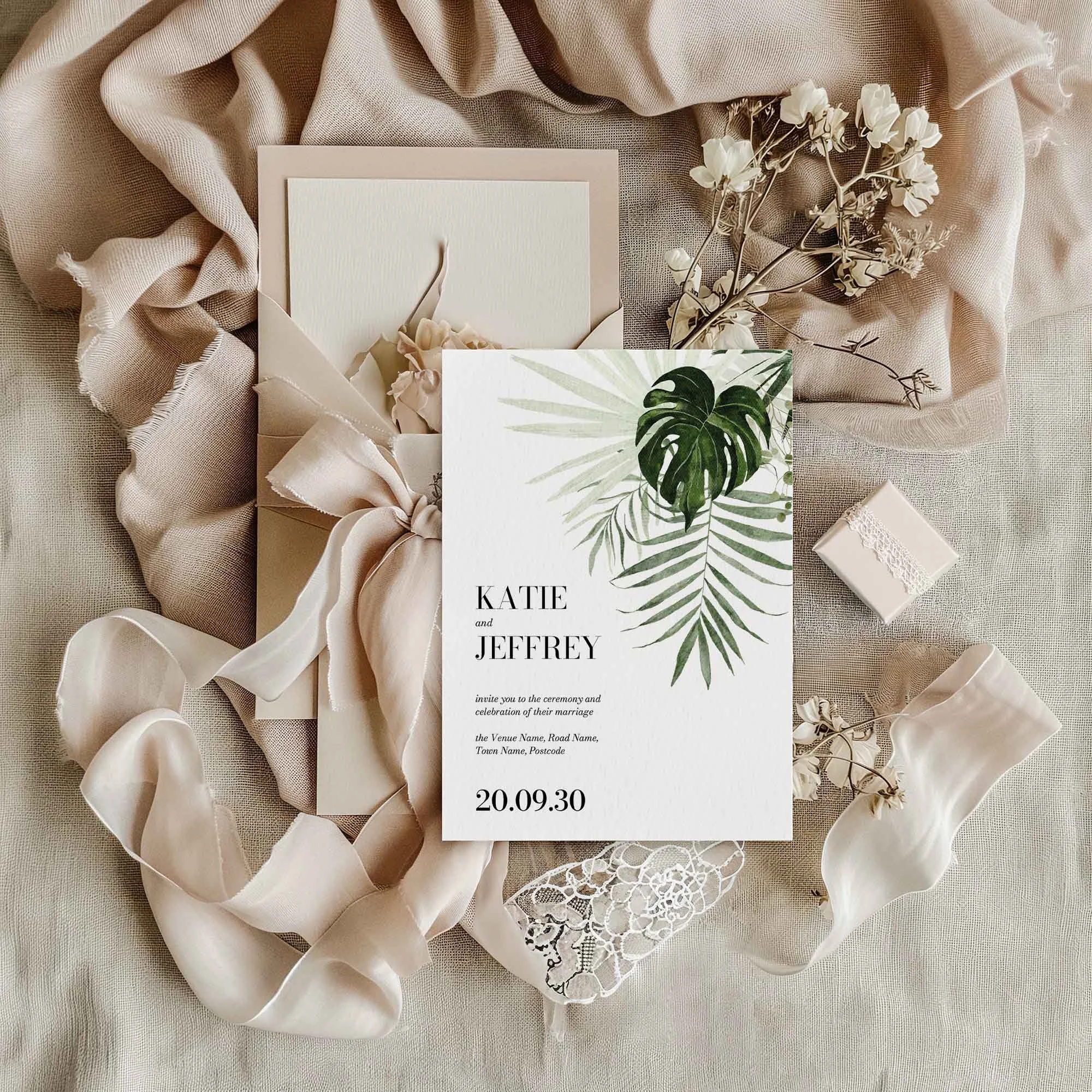 Tropical Leaves wedding invitation styled in a flat lay environment with wedding props