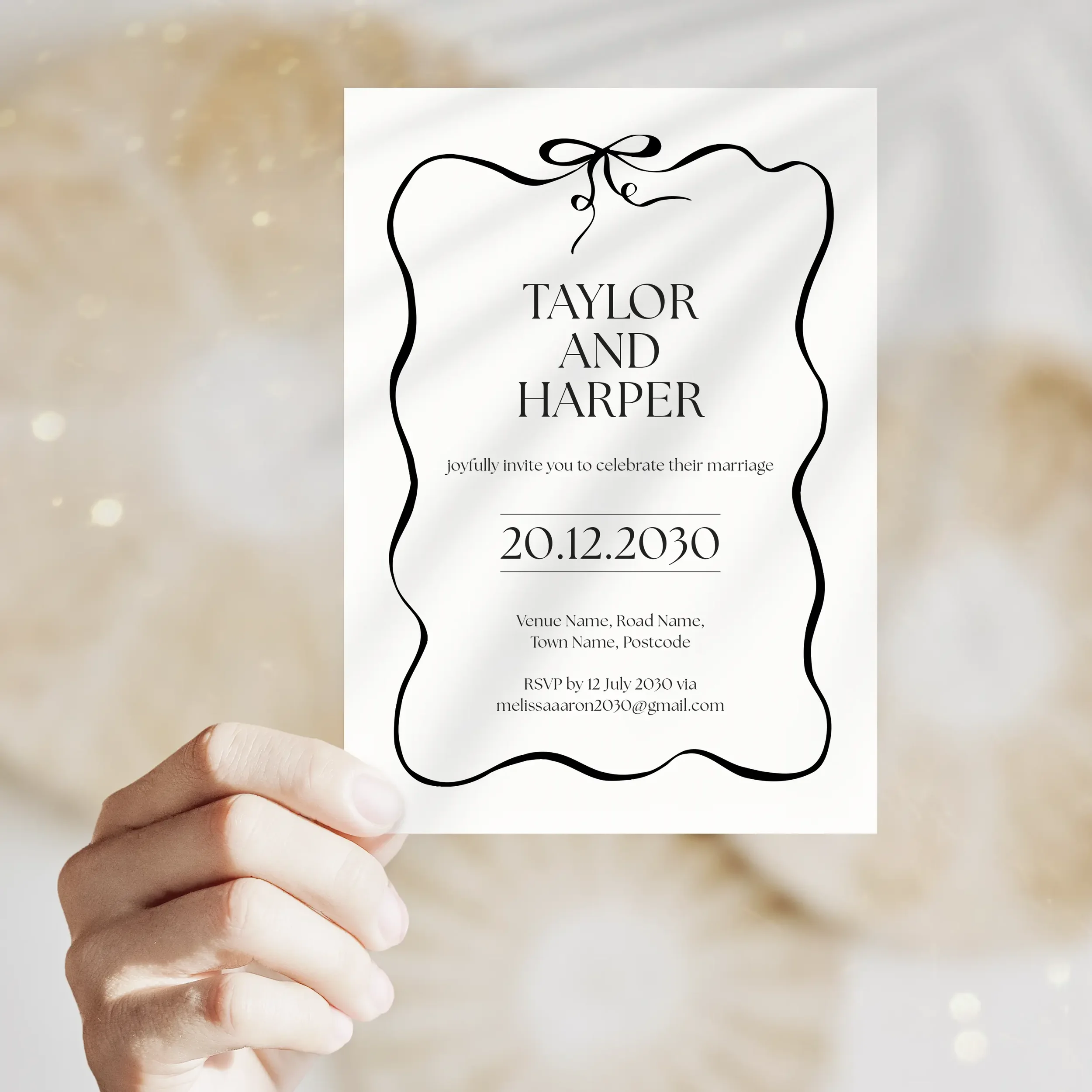 Person holding Black Tie Wedding Invitation with monochrome and bow design.